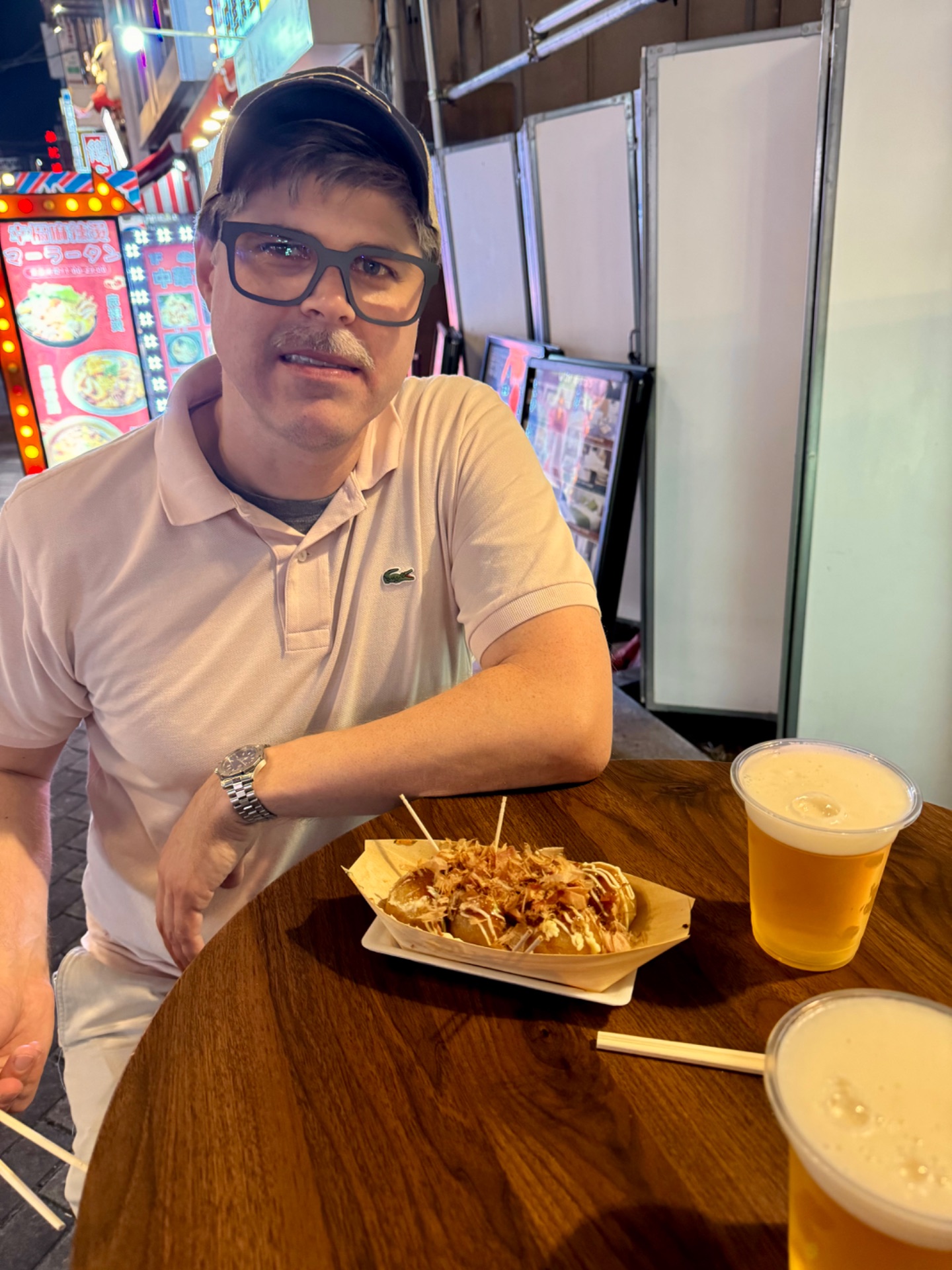 Man enjoying Asian cuisine and beer at a casual dining venue on a cruise ship.