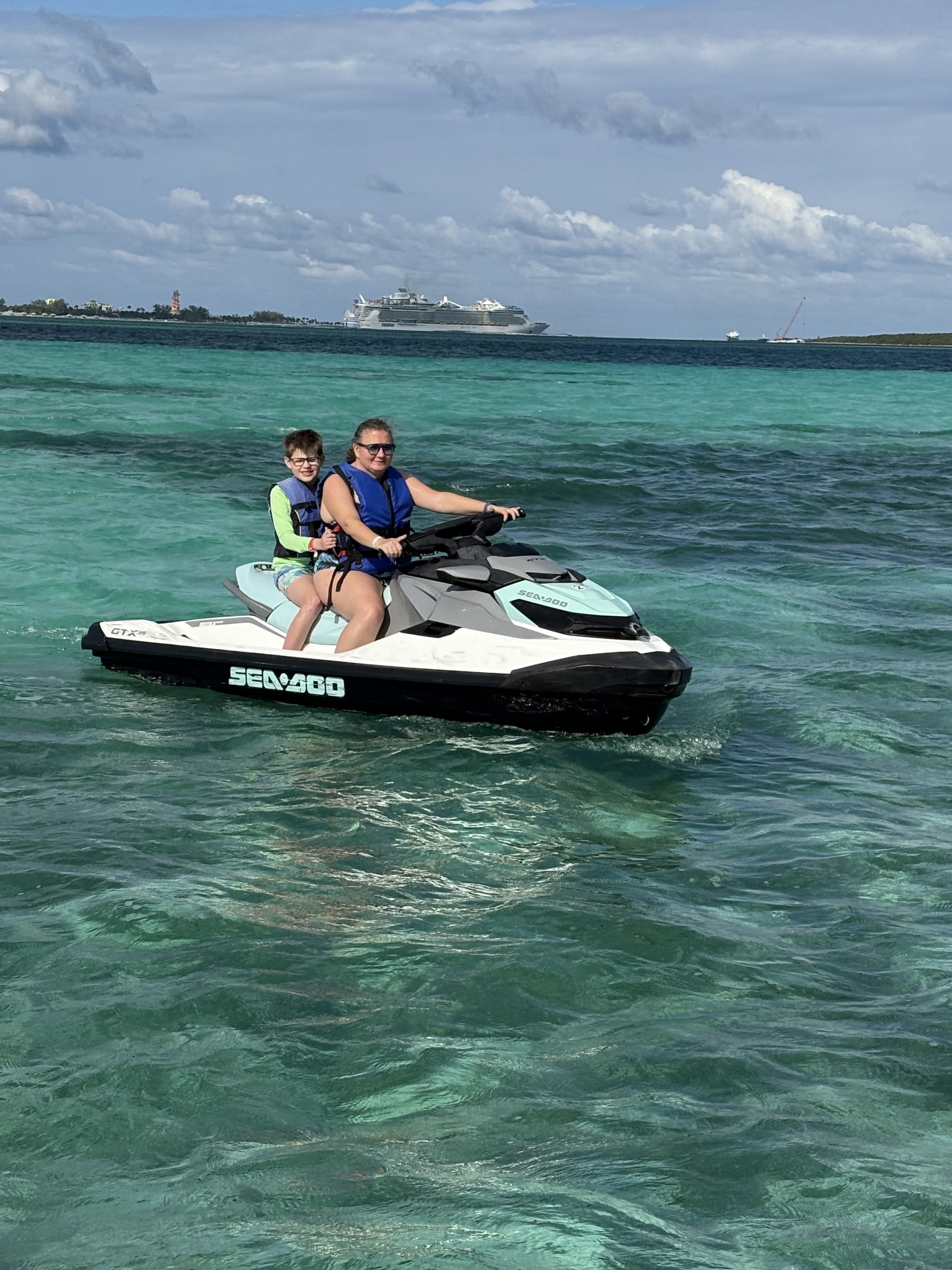 Adult and child on Sea-Doo jet ski in turquoise Caribbean waters