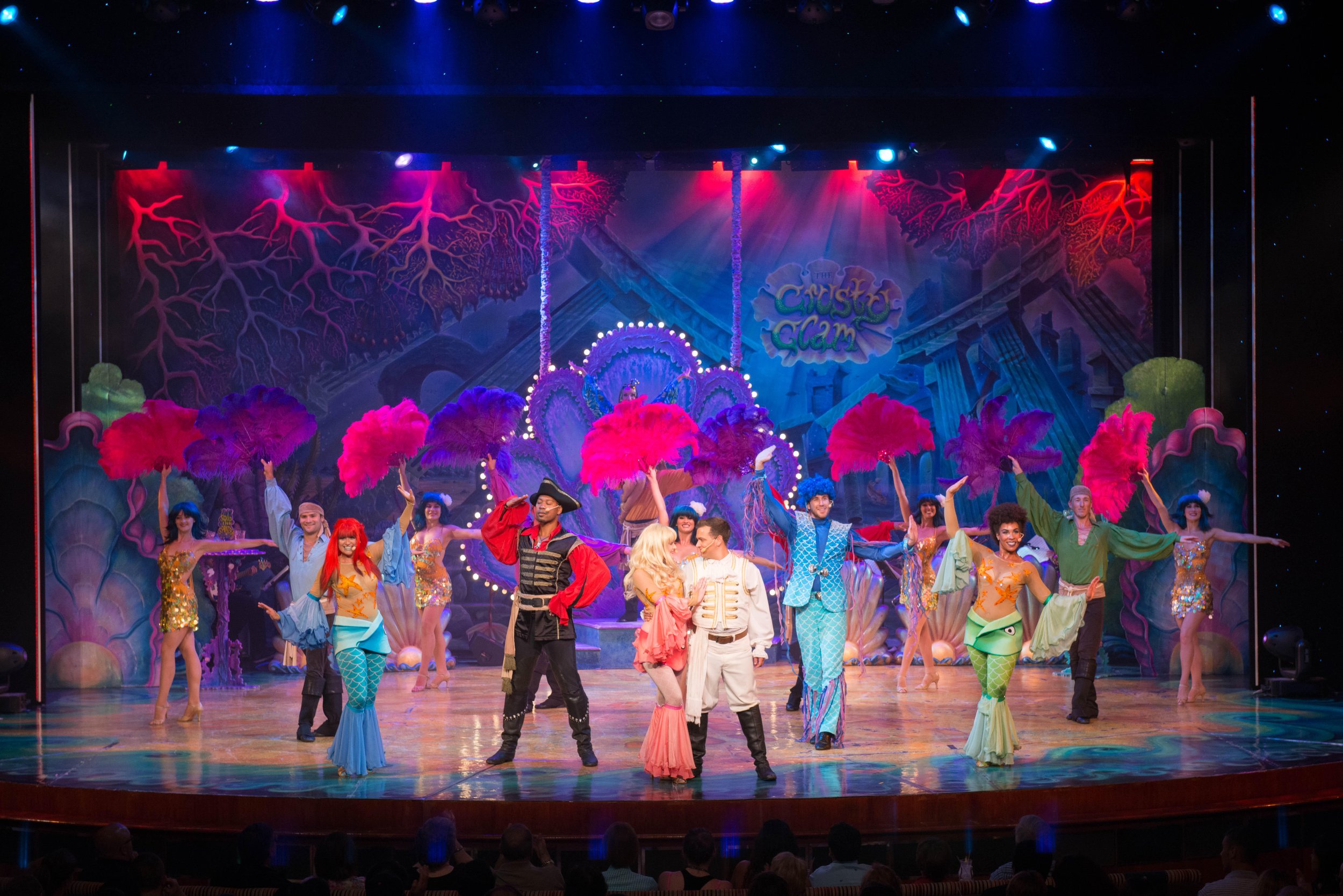 Colorful theatrical stage production with dancers in vibrant costumes and elaborate set design