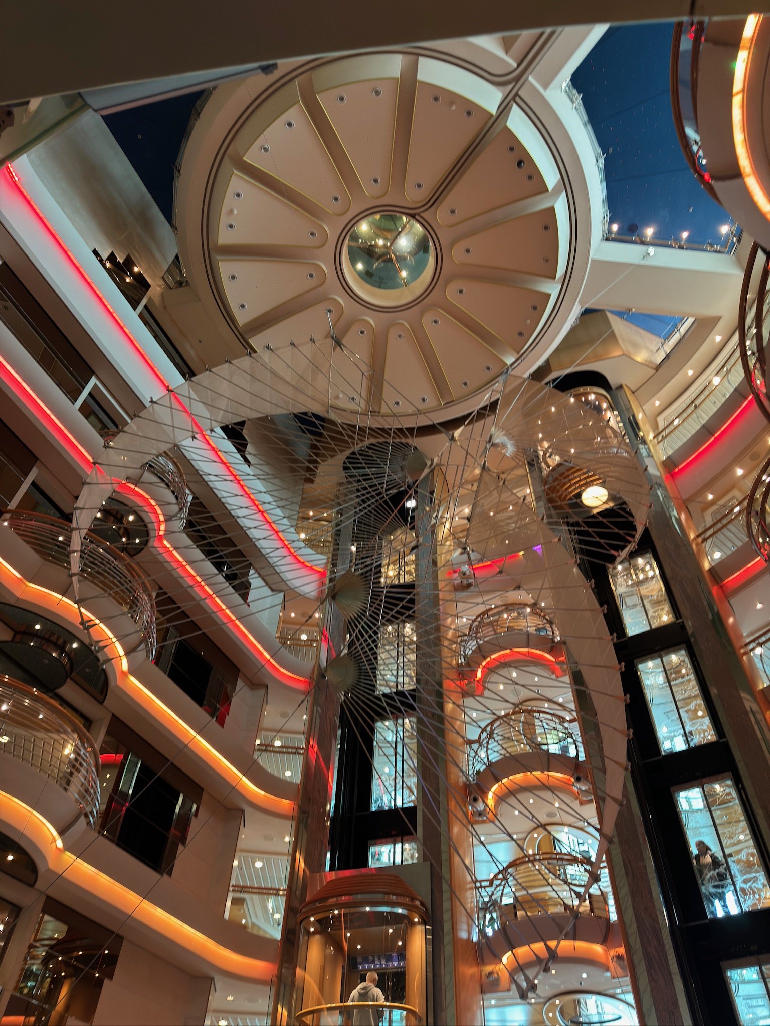 Cruise ship atrium with circular skylight and spiral staircase at night