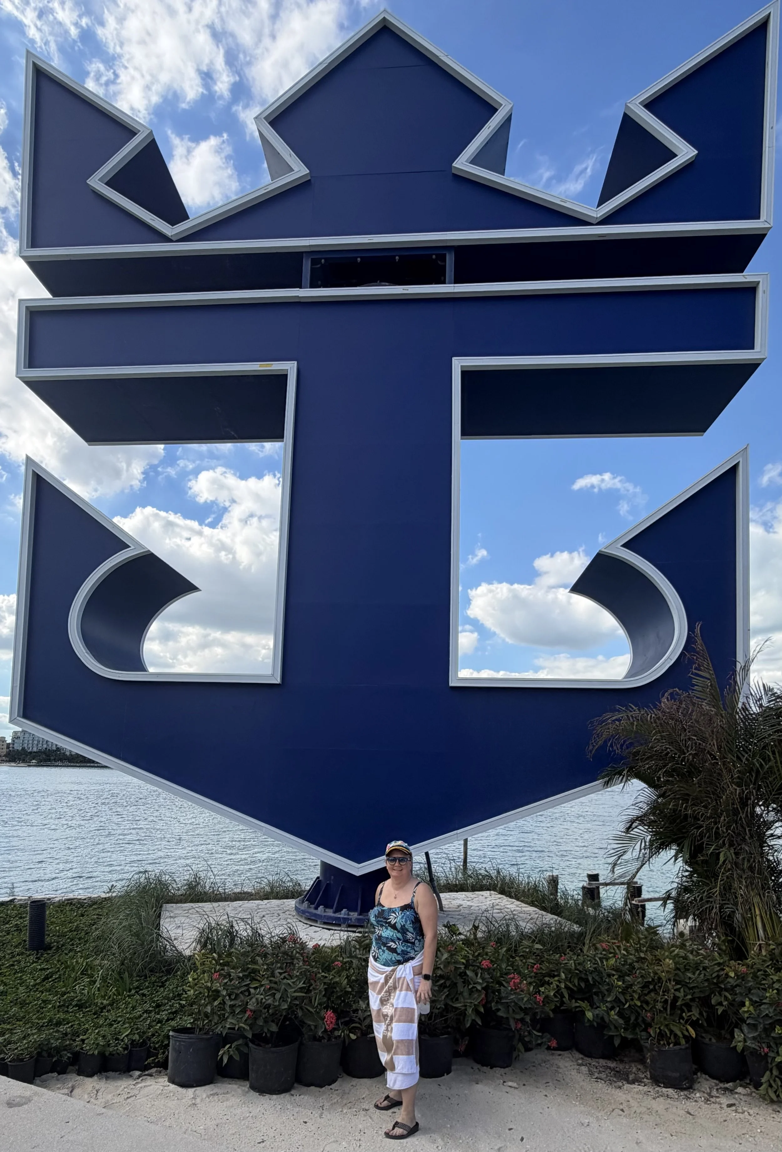 Woman posing at large blue ship head sculpture waterfront