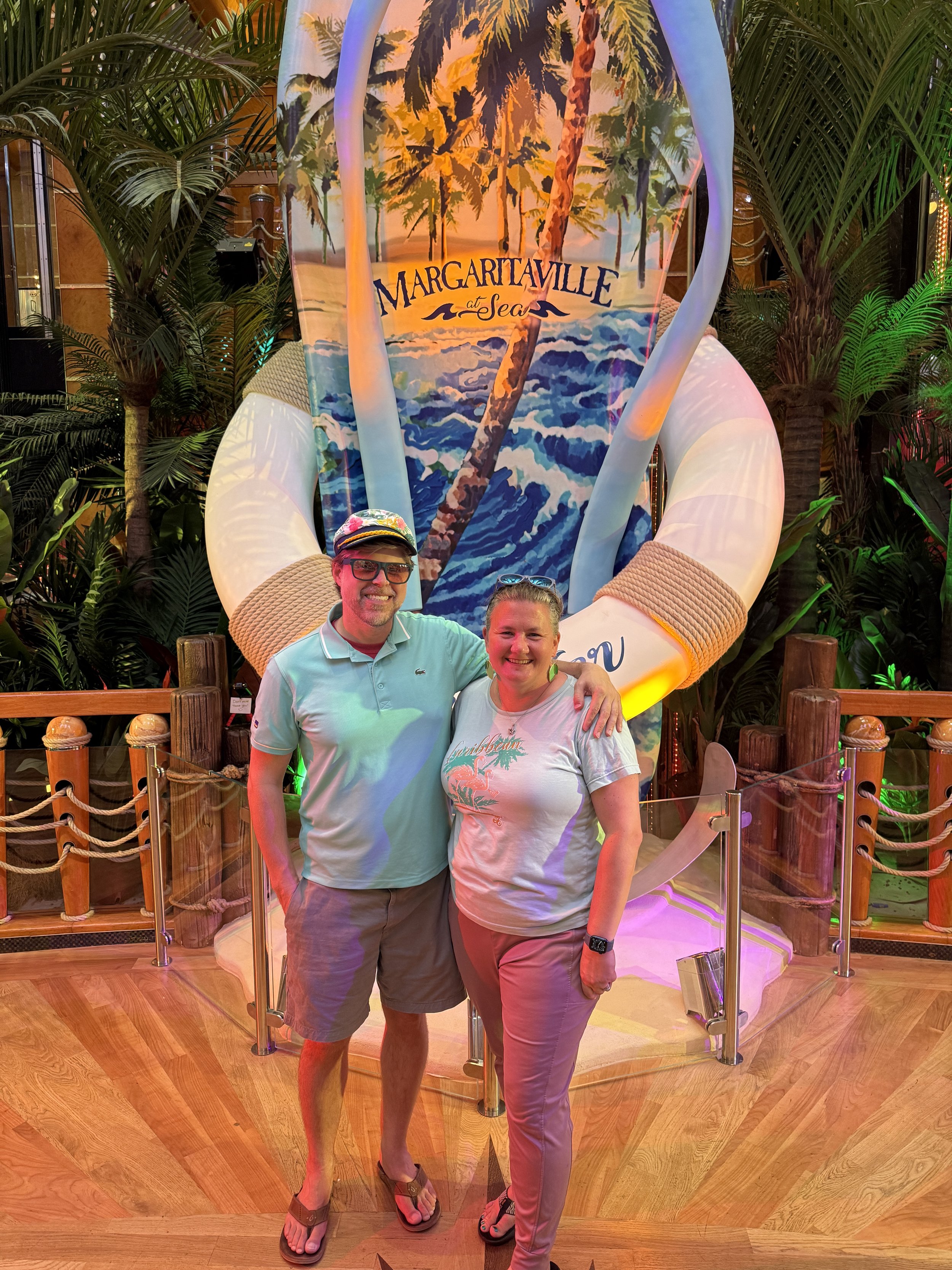 Two guests pose at Margaritaville at Sea cruise ship display