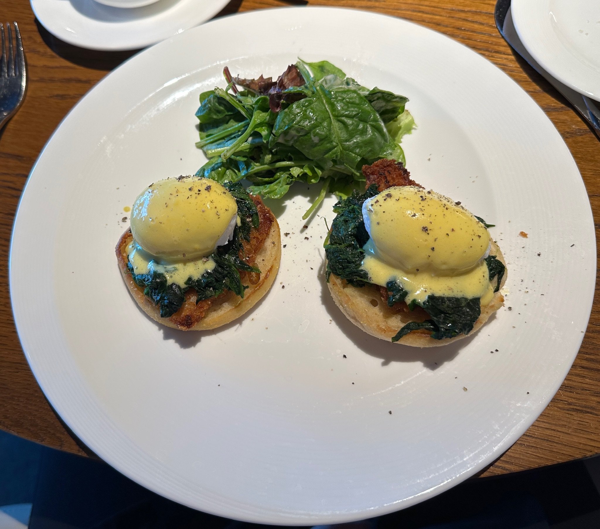Eggs Benedict with sautéed spinach and fresh greens salad