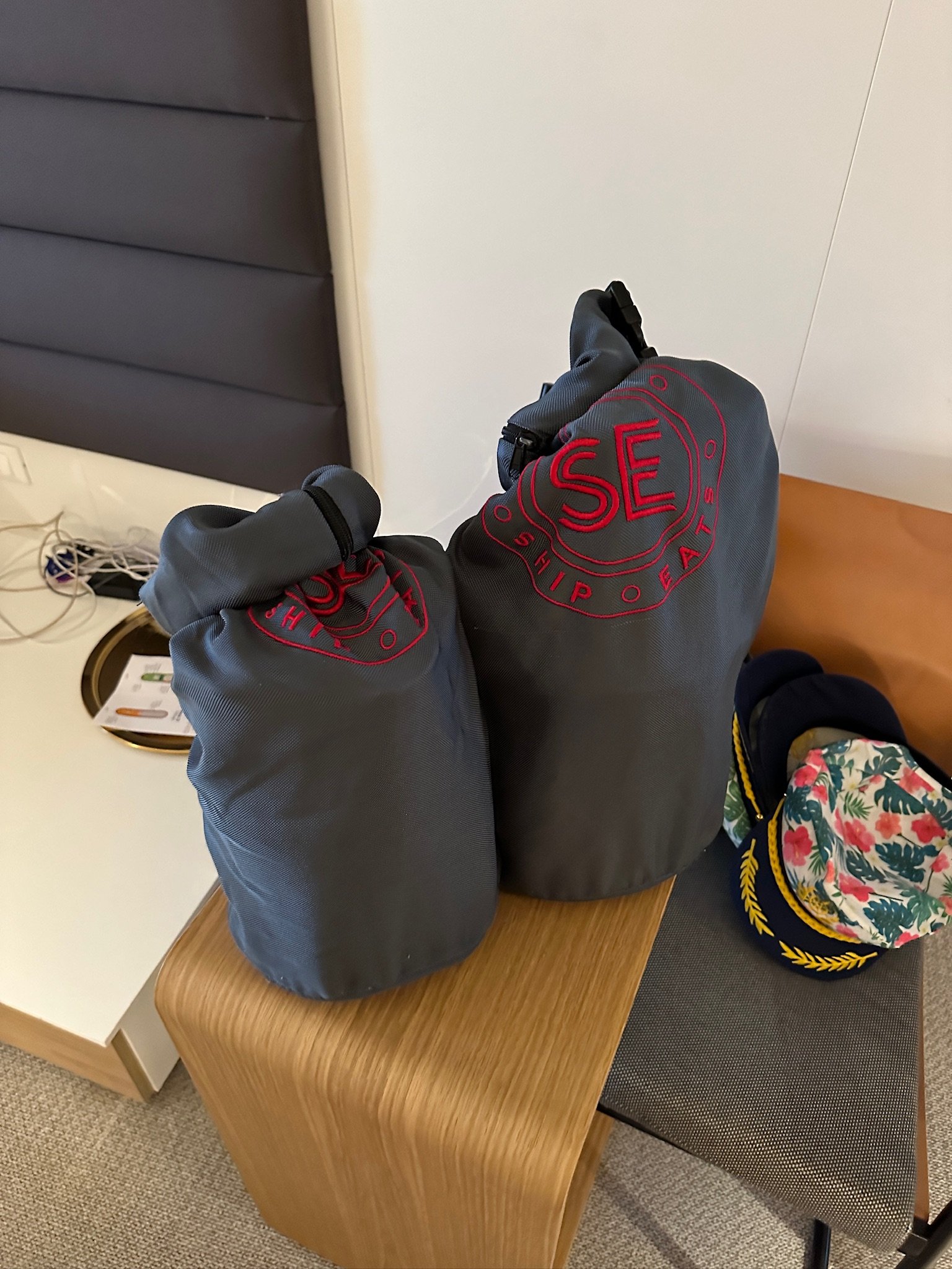 Gray ship tote bags with red "Sea" logo design displayed