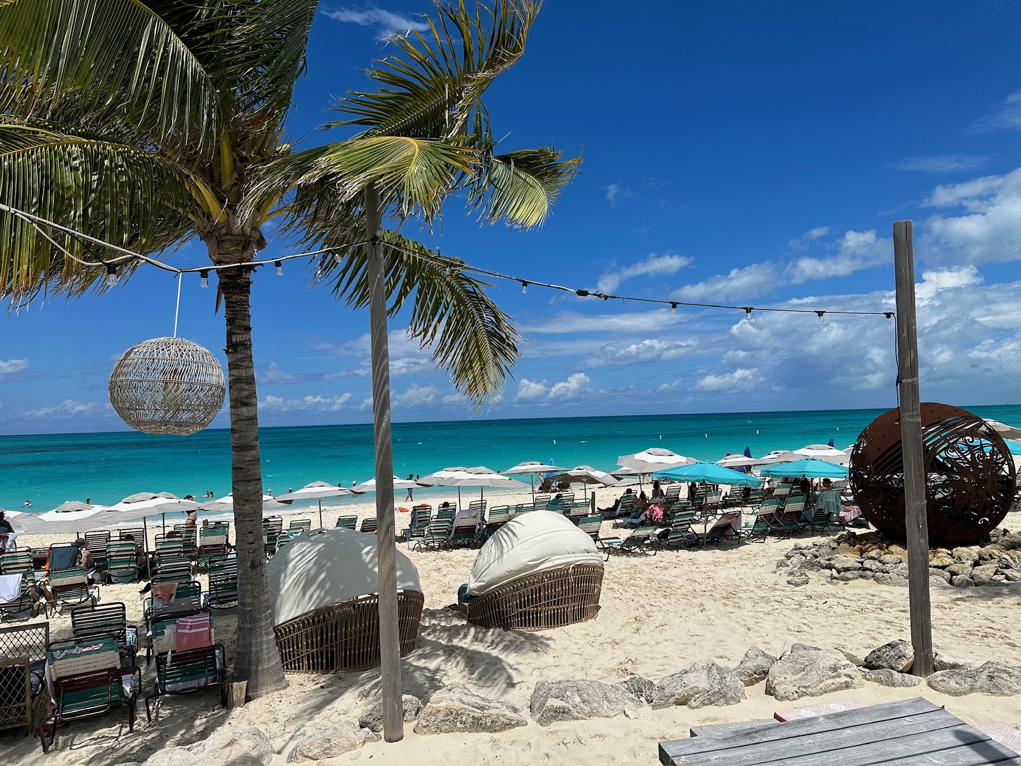Turquoise beach with lounge chairs and palm trees
