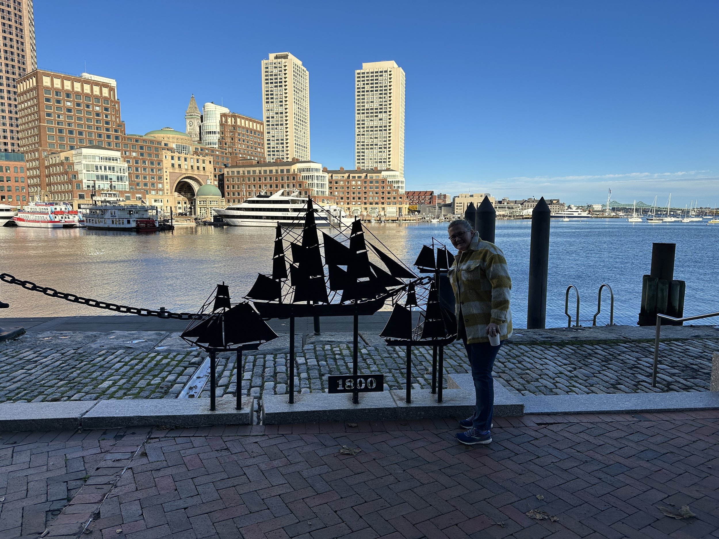Person viewing Boston Harbor waterfront historical ship sculpture