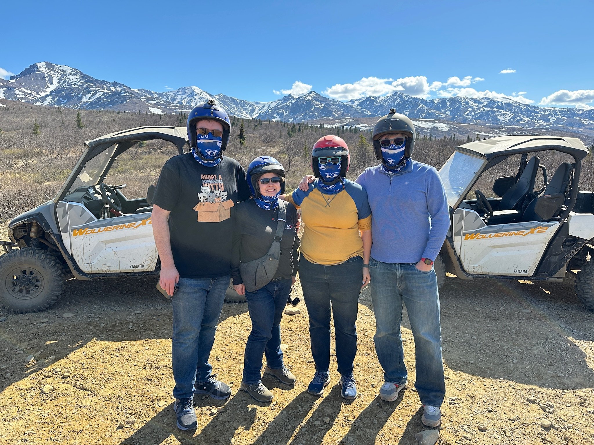 # Alt Text

Group poses with Yamaha ATVs in snowy mountain valley