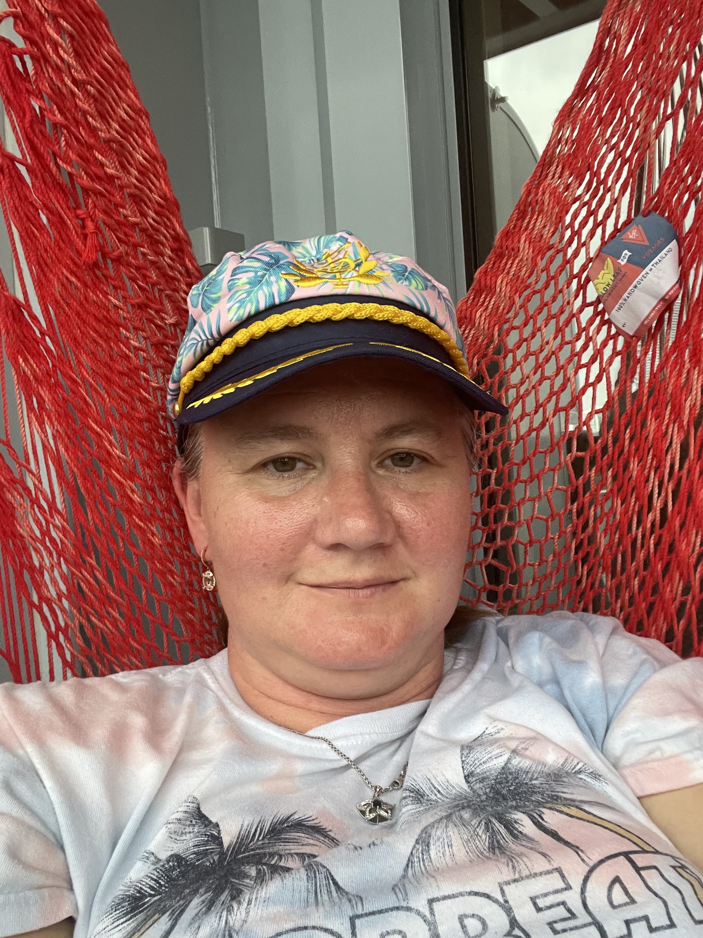 Woman in colorful captain hat on cruise ship balcony