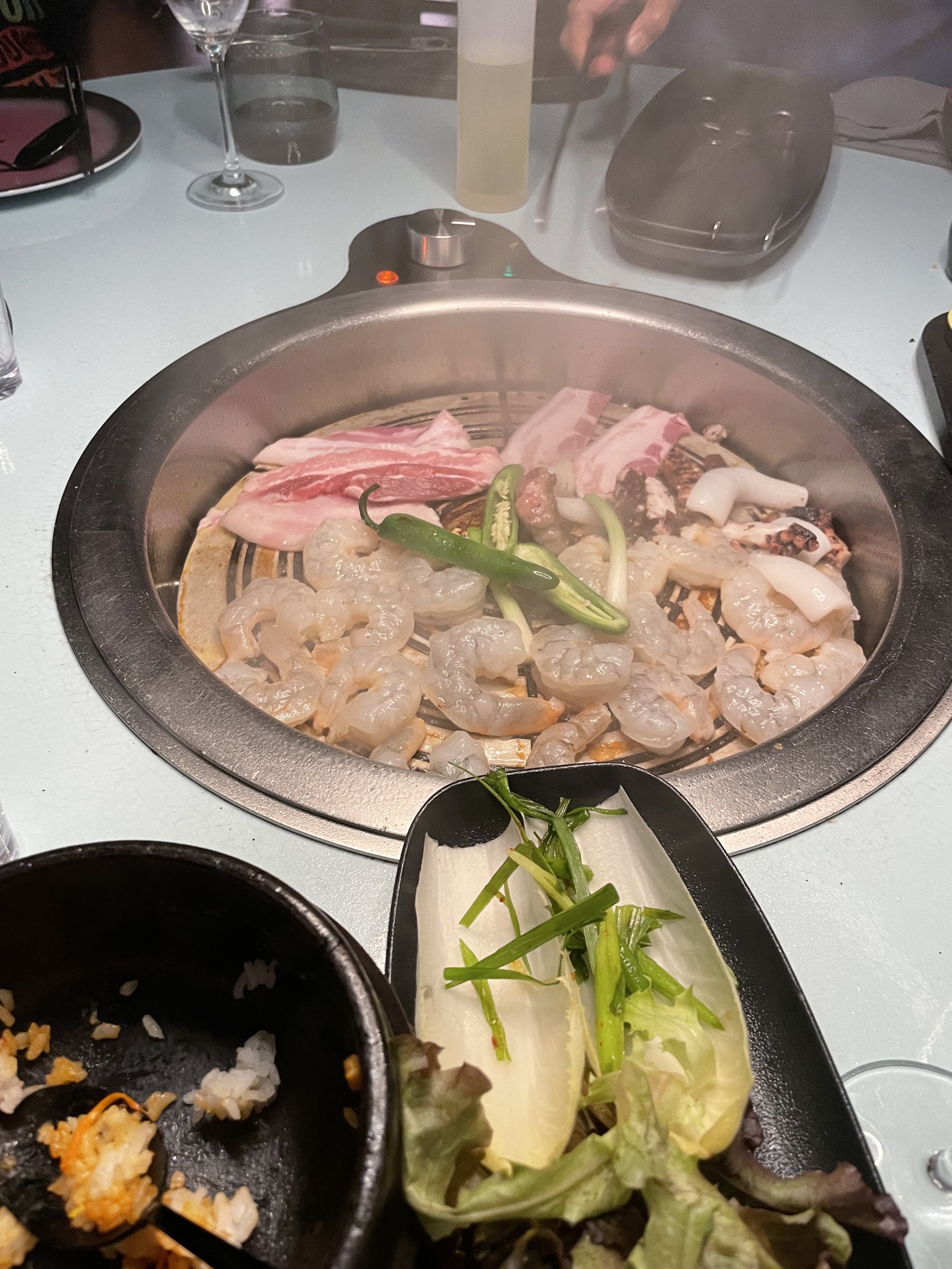 Tableside Korean BBQ cooking with seafood and beef slices