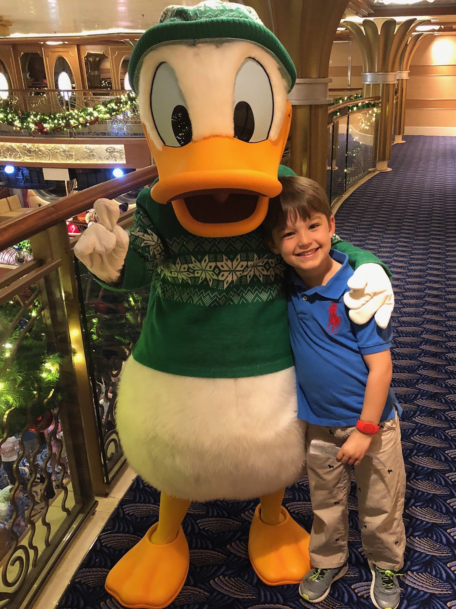 Young boy poses with Donald Duck character on cruise ship