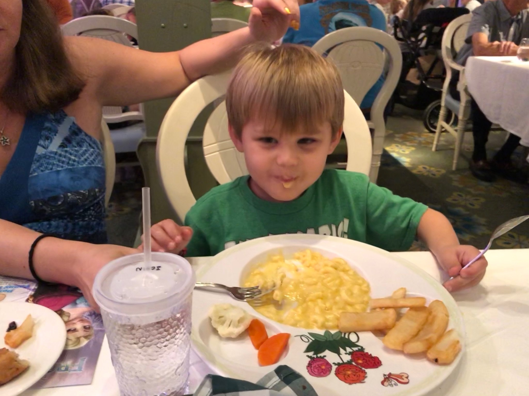 Young boy eating mac and cheese at cruise ship dining