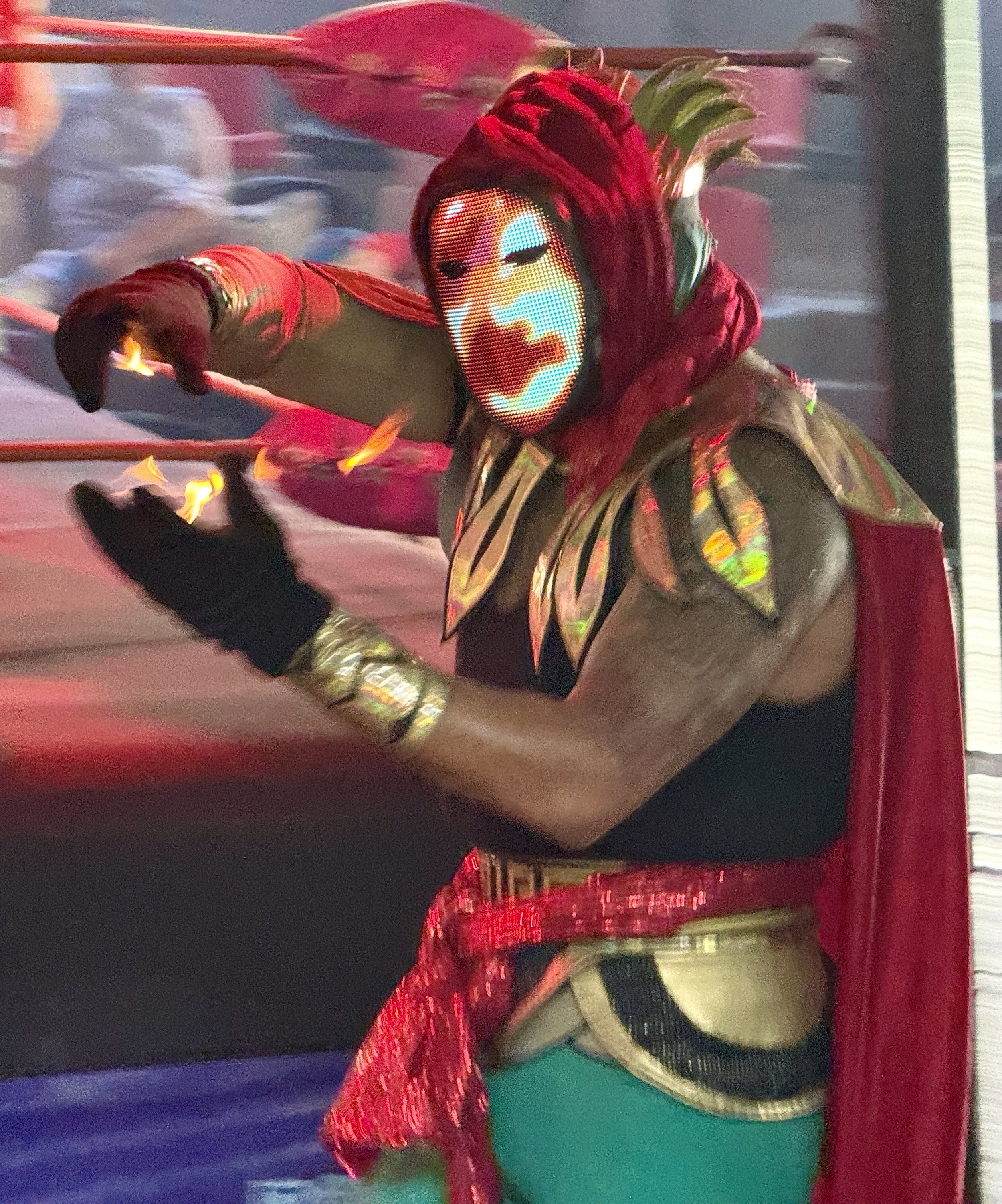 Performer in red costume with illuminated face mask on cruise ship stage