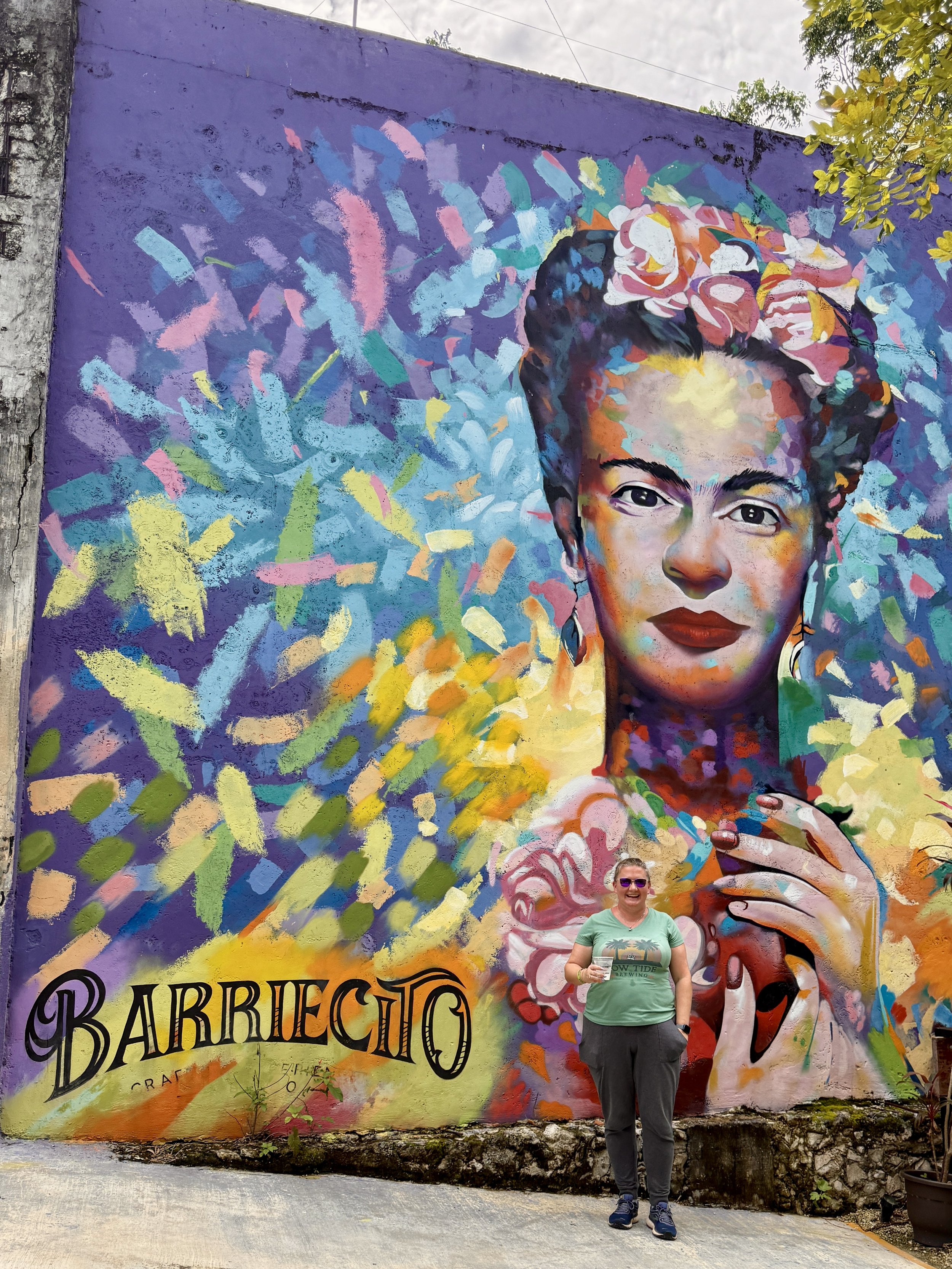 Woman posing before colorful Barreiro street art mural portrait