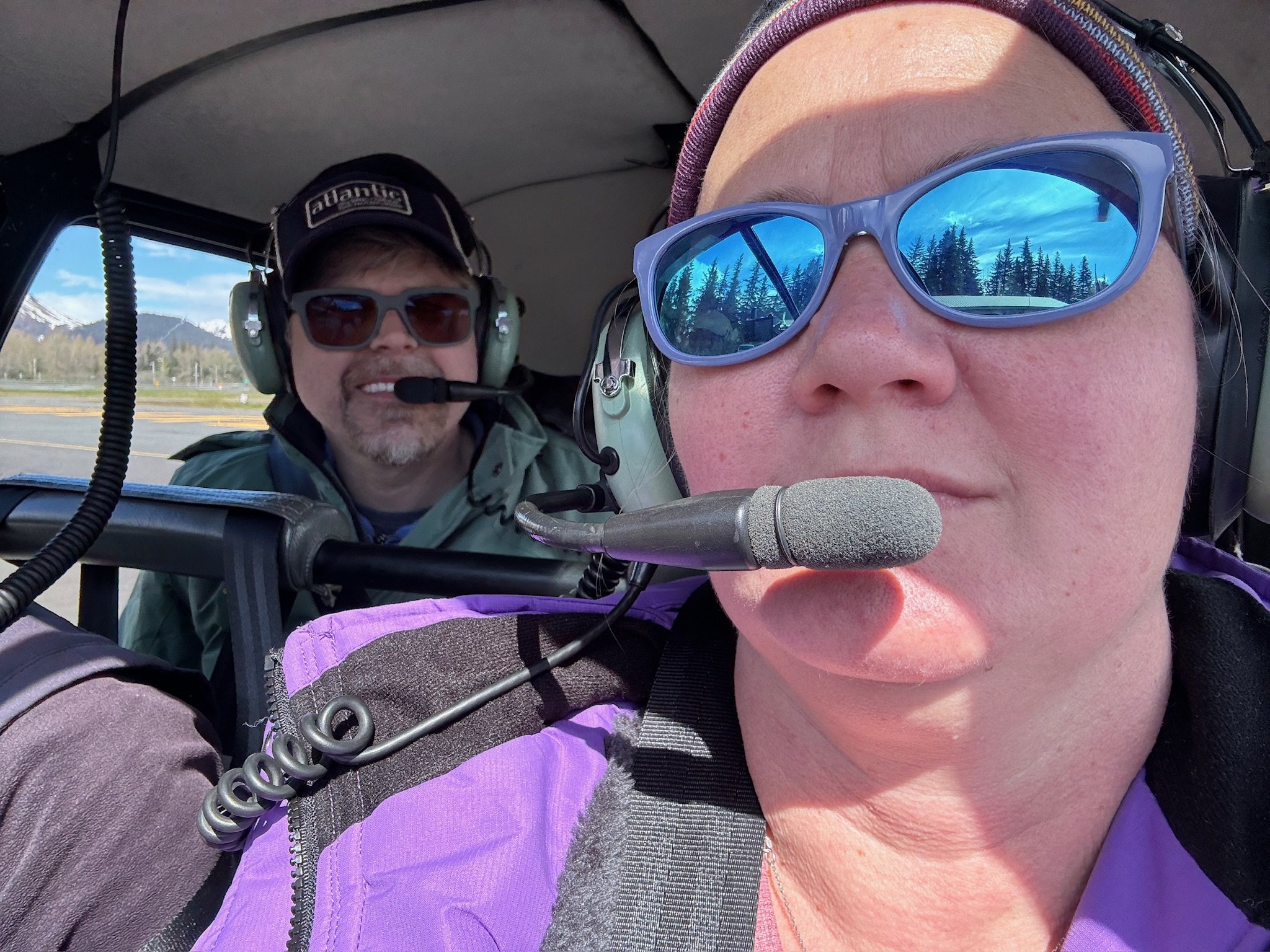 Two pilots in small aircraft cockpit with headsets during flight