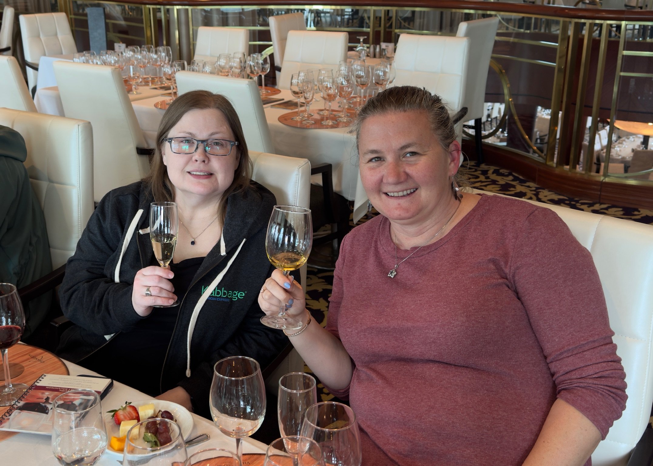 Two women toasting with wine glasses at elegant dining room