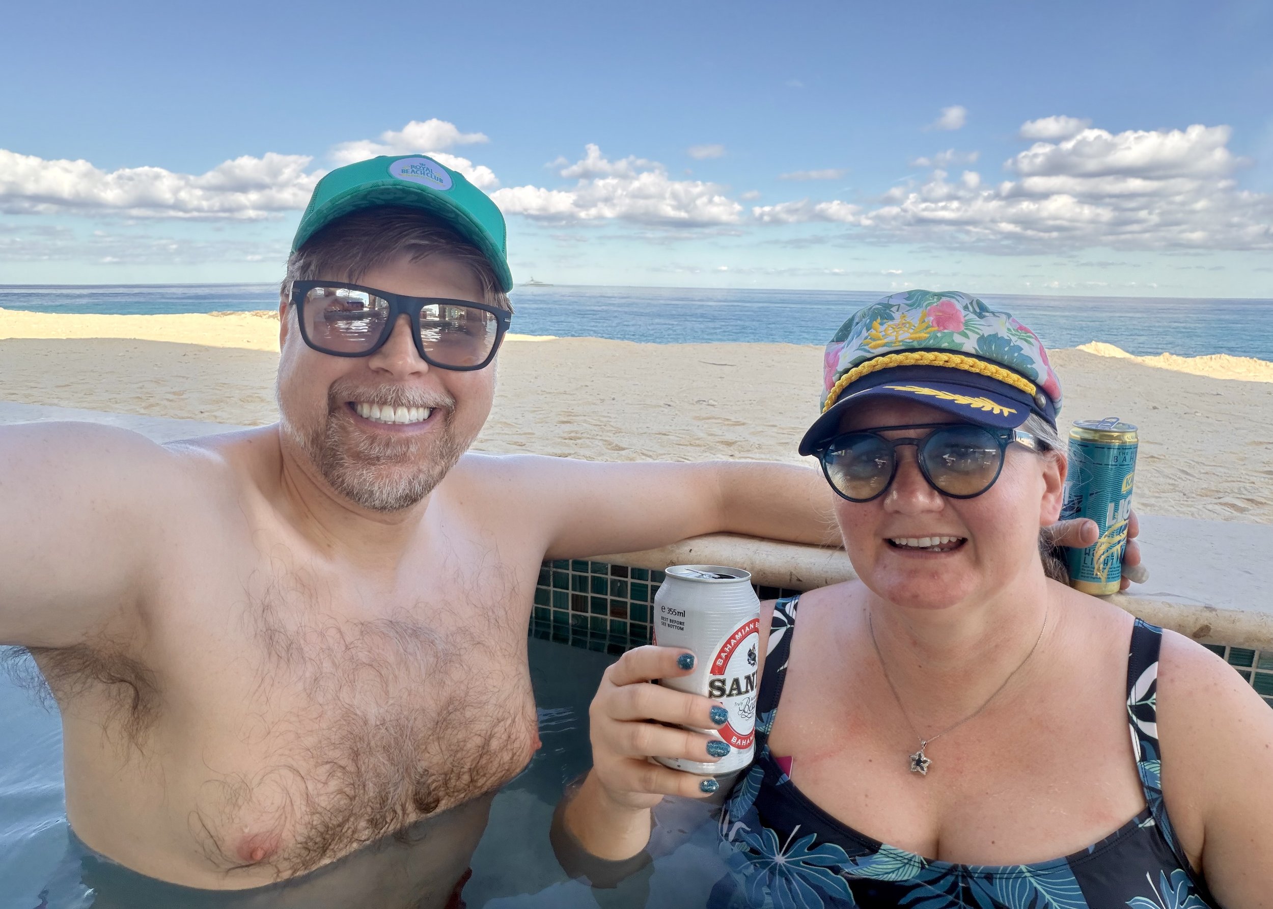 Two people enjoying beach day with drinks and ocean view