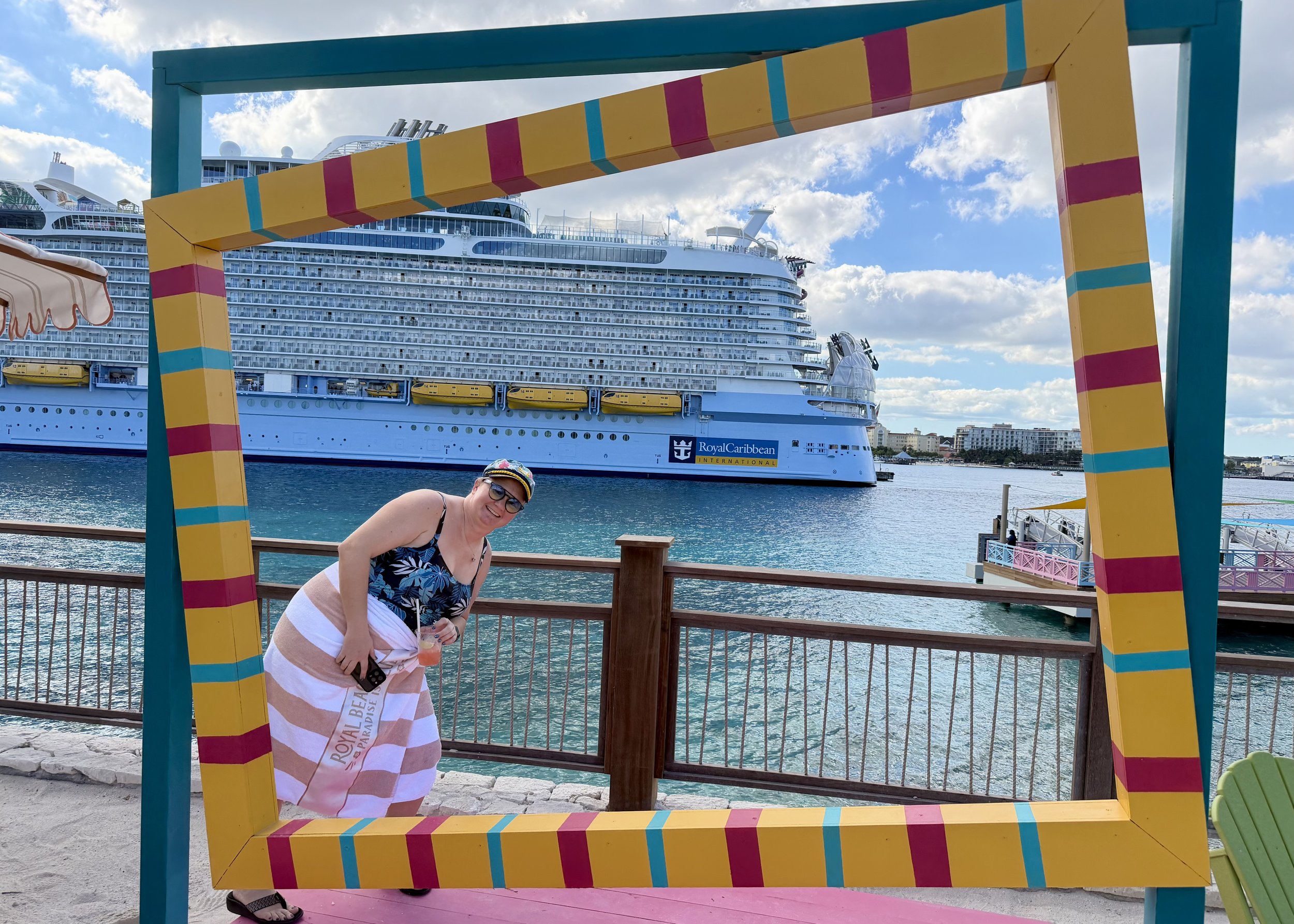 Woman posing at colorful frame with Royal Caribbean cruise ship