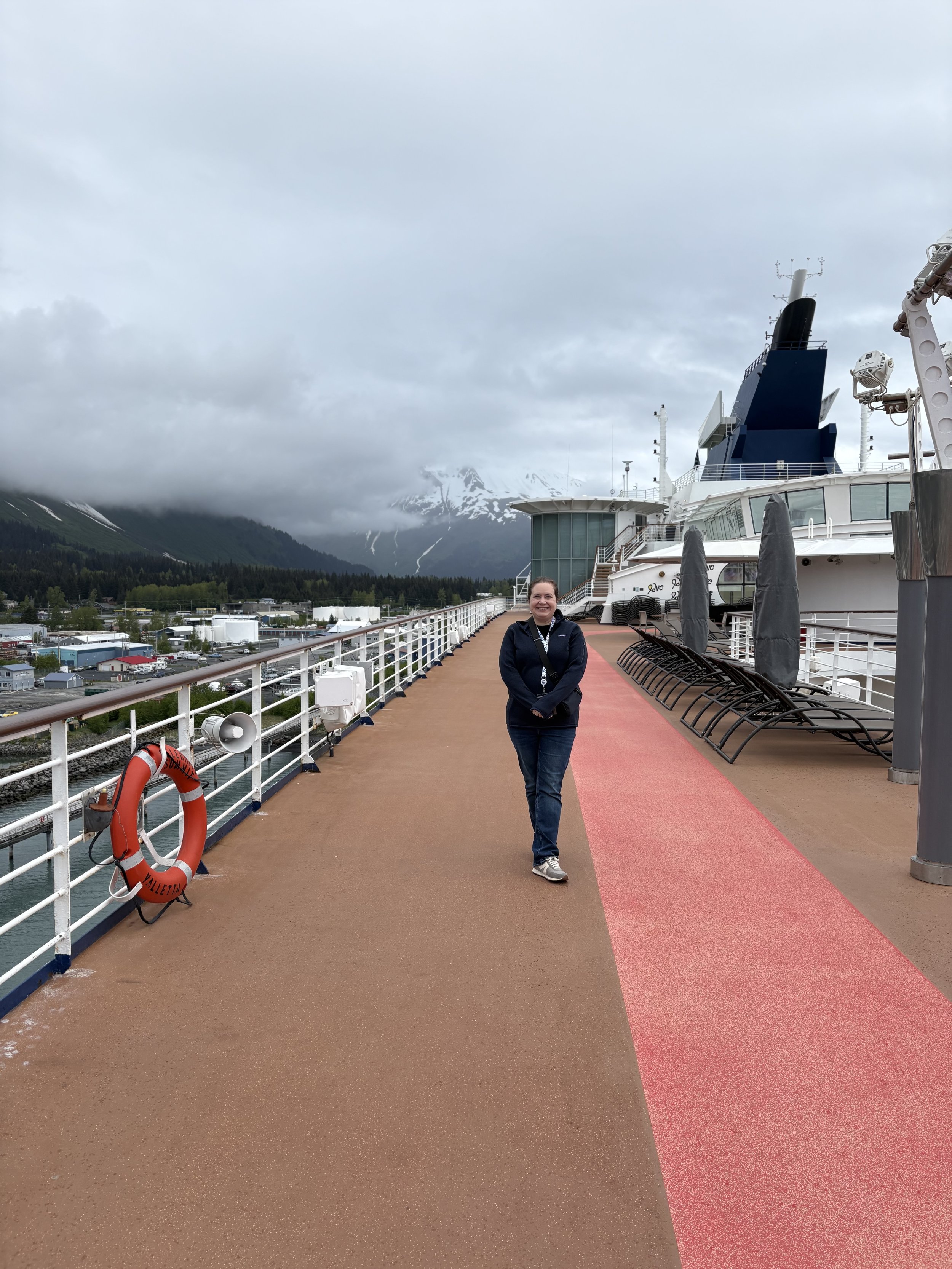 Woman on cruise ship deck with snow-capped mountains