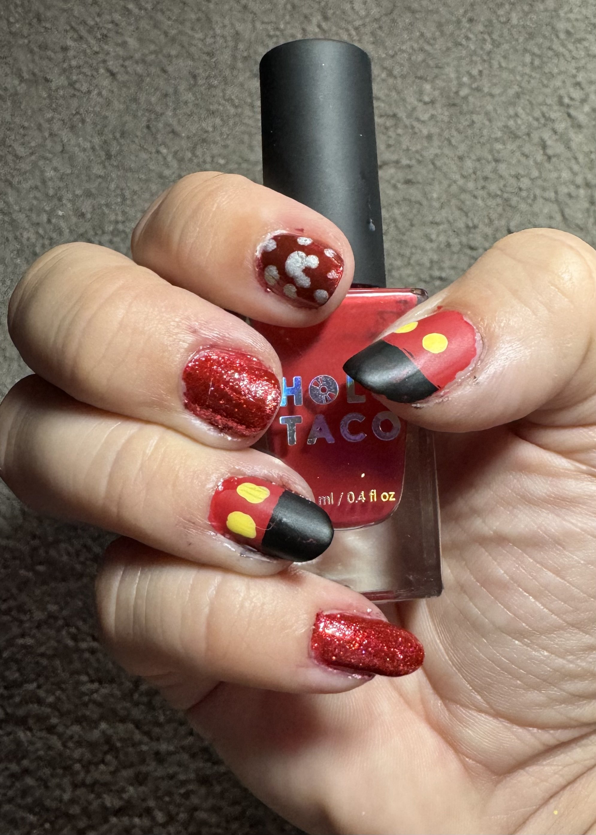 Mickey Mouse themed nail art design with red polish bottle