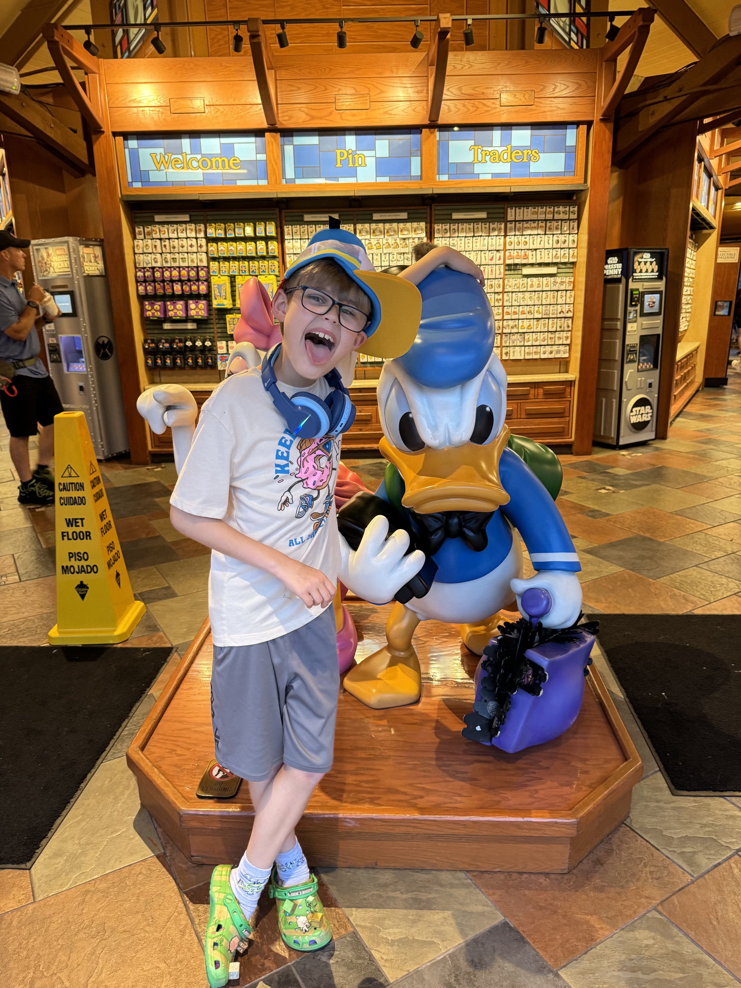 Boy poses with Donald Duck character at cruise ship pin traders