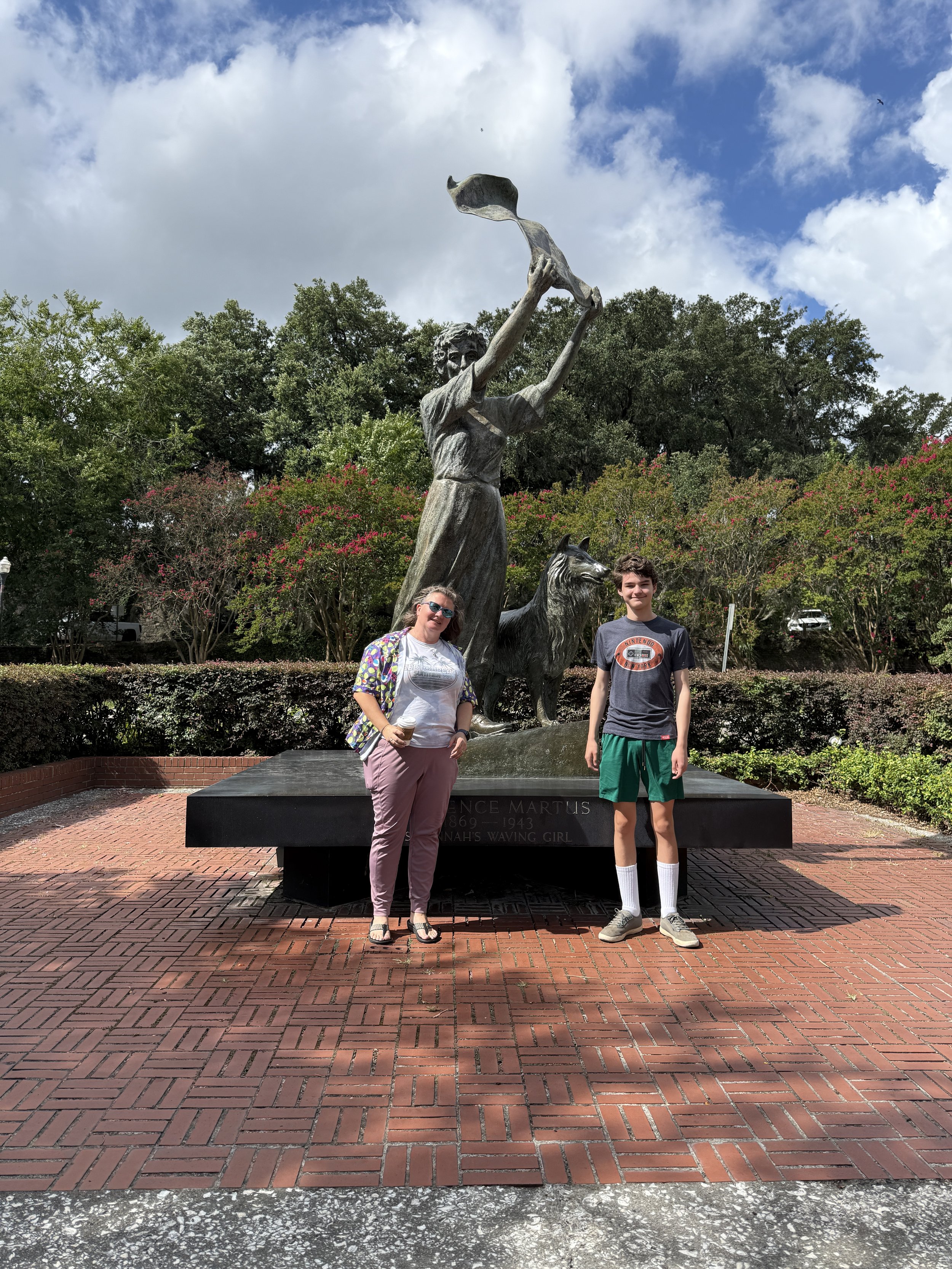 Two visitors pose at Savings Girl statue monument