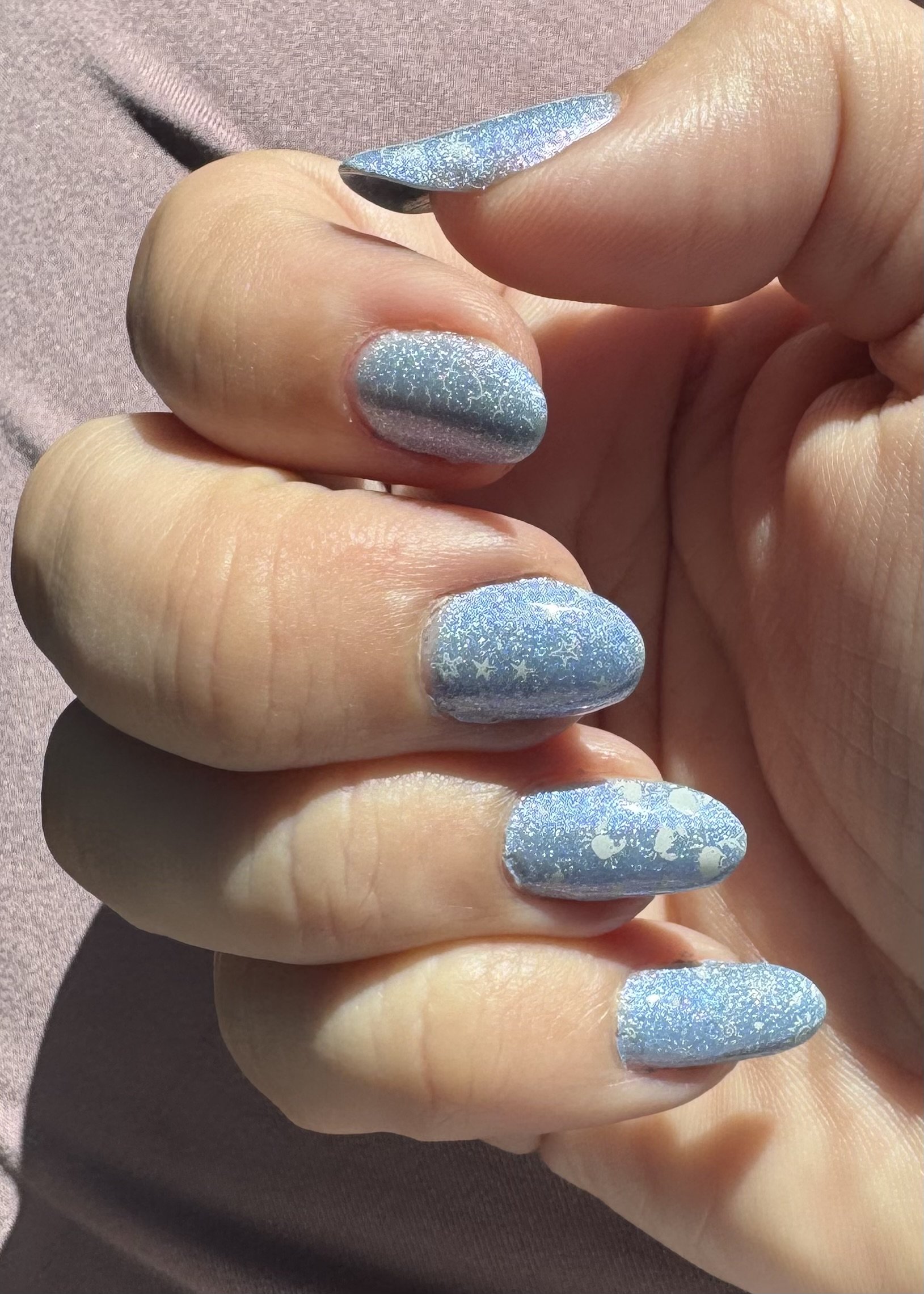 Blue glitter nail polish manicure on fingernails