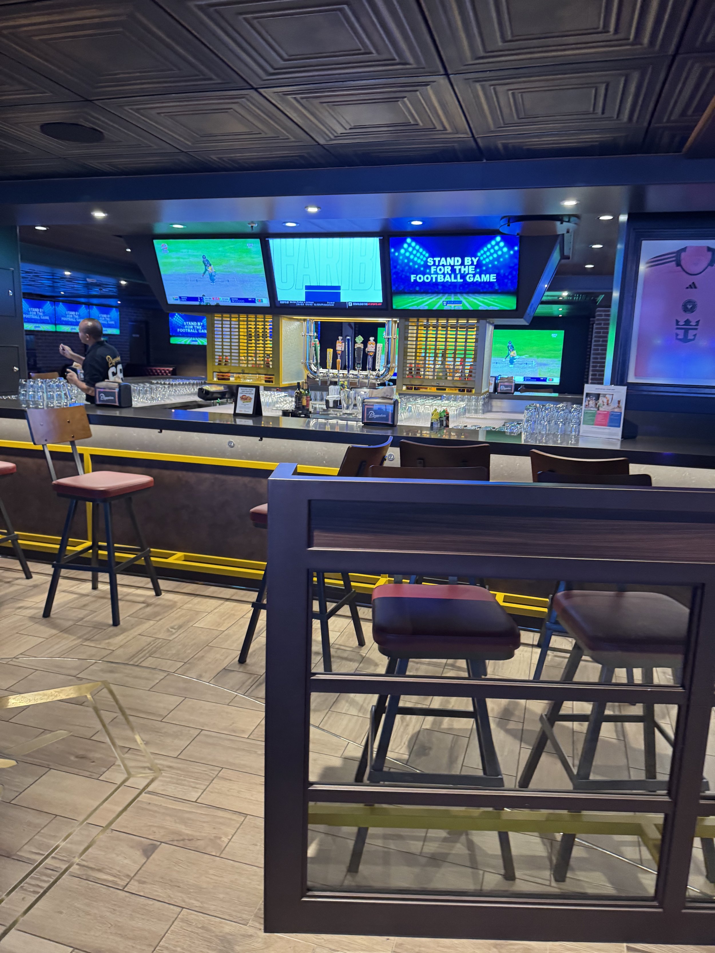 Modern sports bar with multiple screens showing football games
