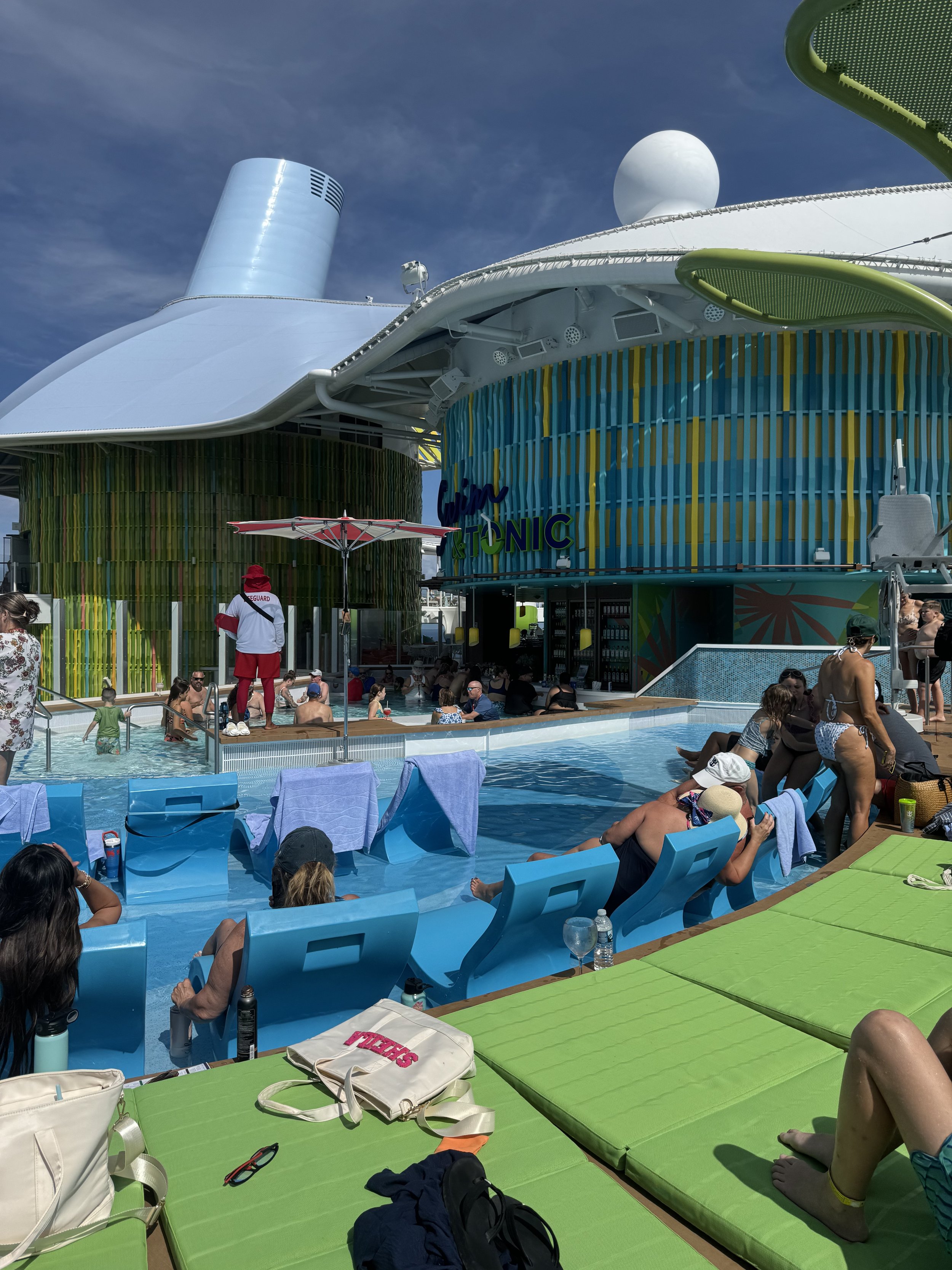 Passengers enjoying pool deck activities on modern cruise ship