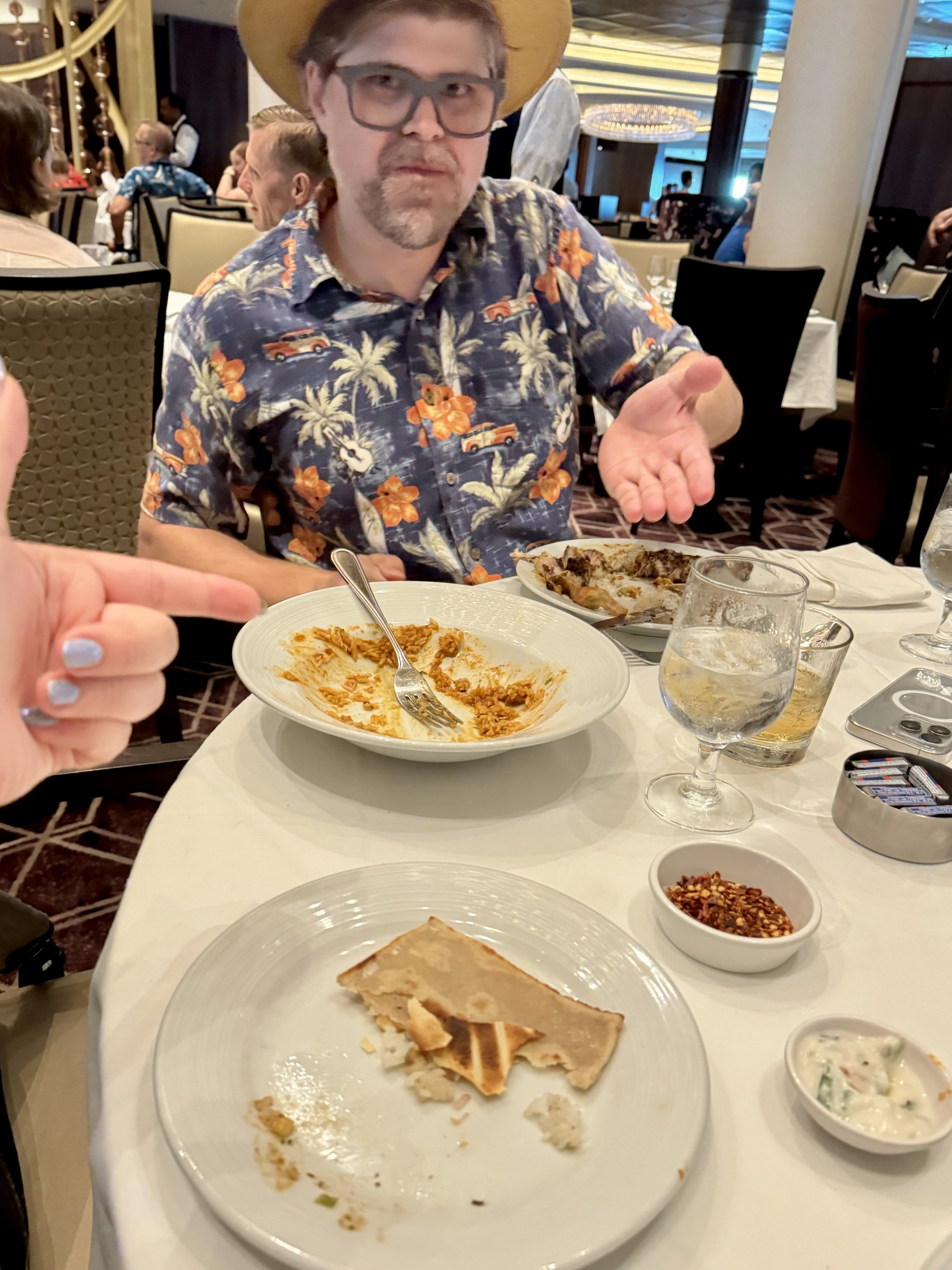 Man in Hawaiian shirt eating crepes at dining table