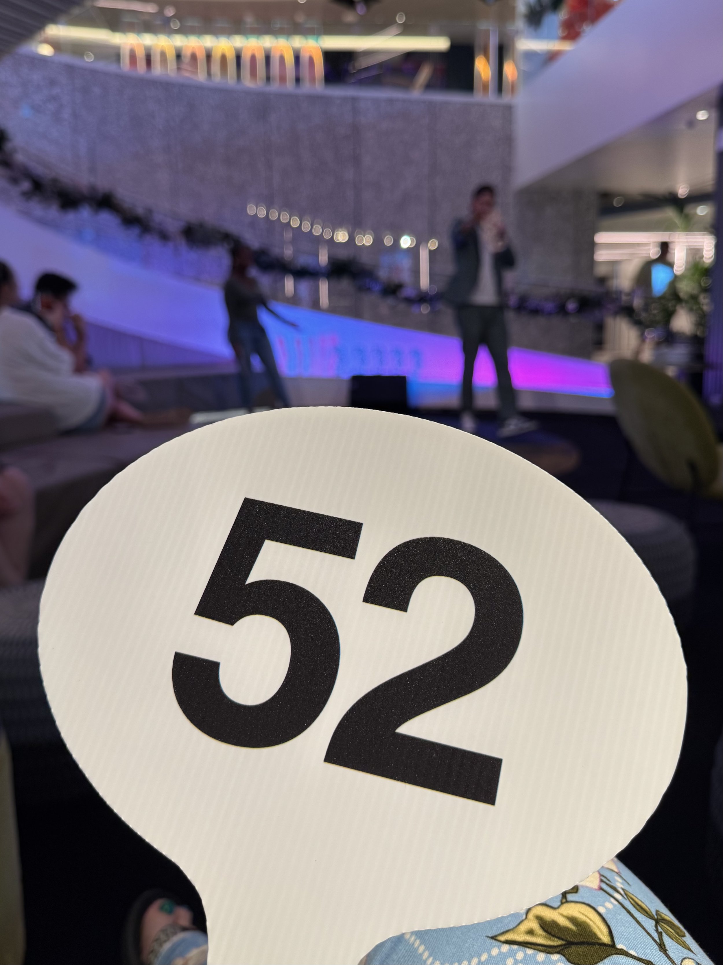 Modern cruise ship lounge with table number fifty-two and purple ambient lighting