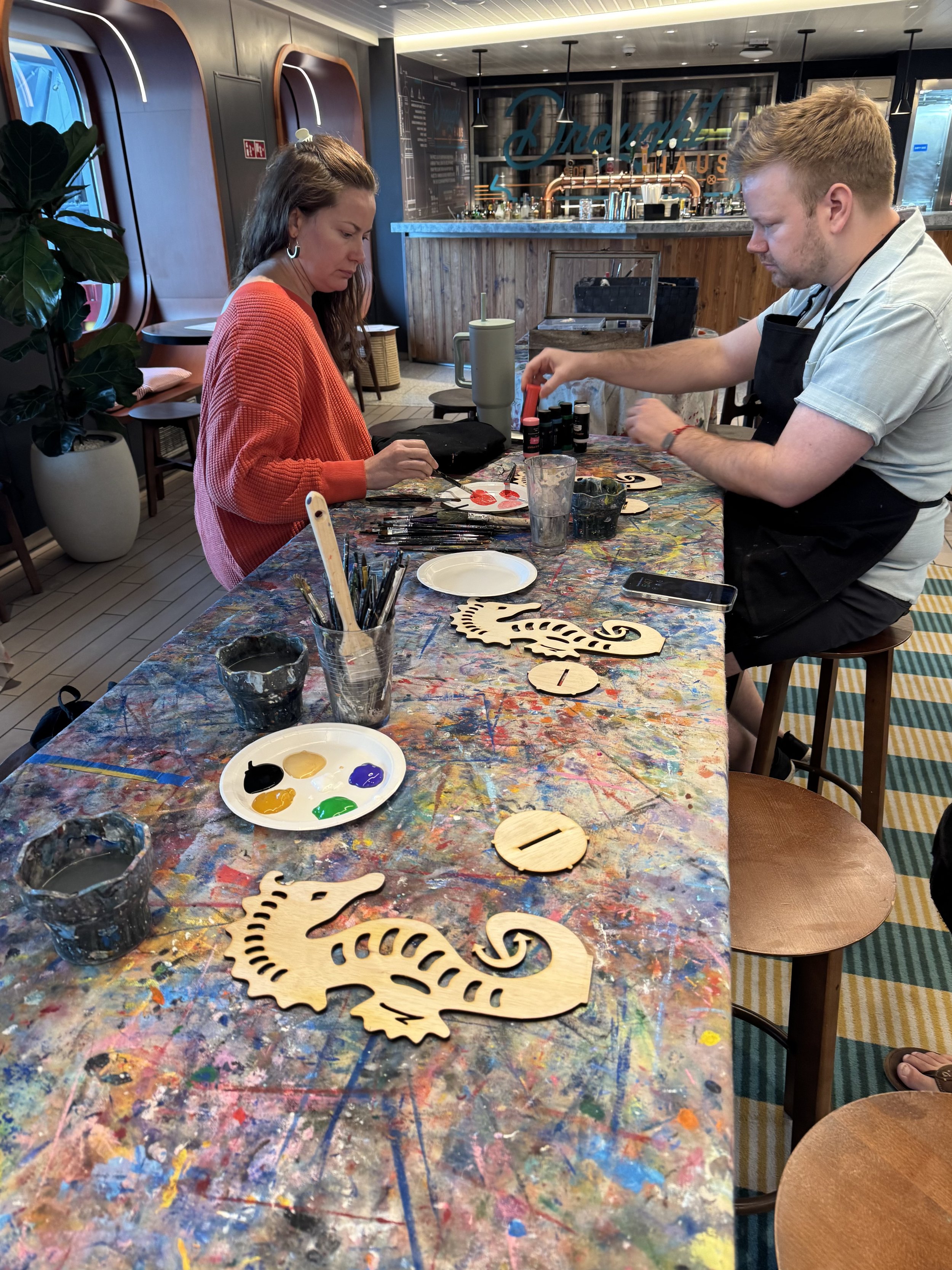 Two guests participate in art painting class activity on cruise ship