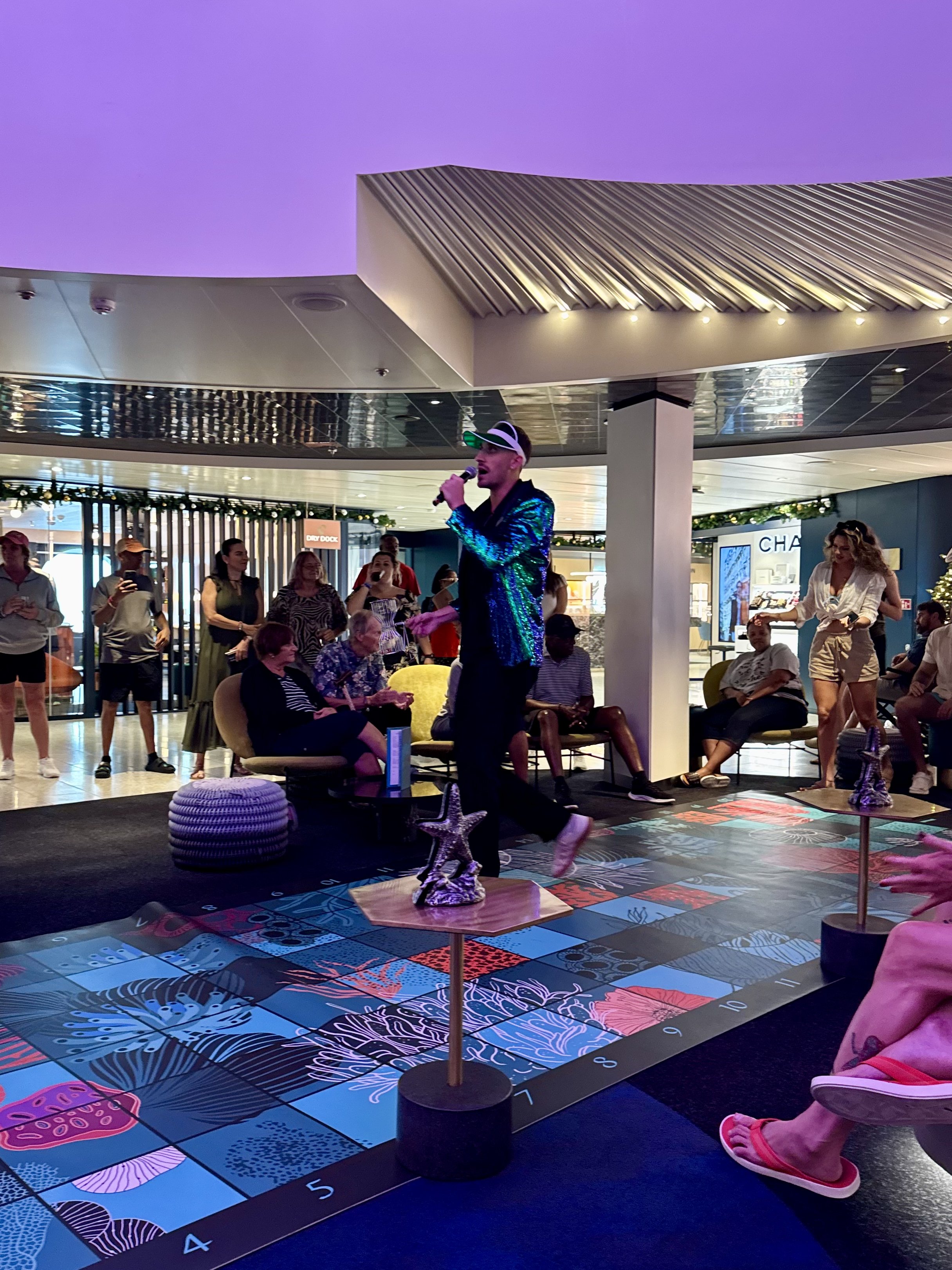 Performer entertains cruise ship passengers in colorful atrium