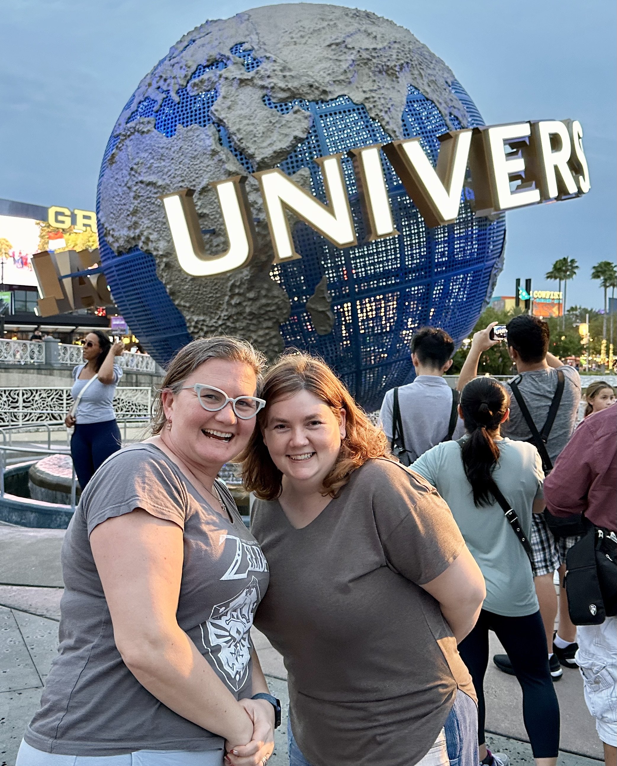 Two women smiling at Universal Studios Orlando globe landmark
