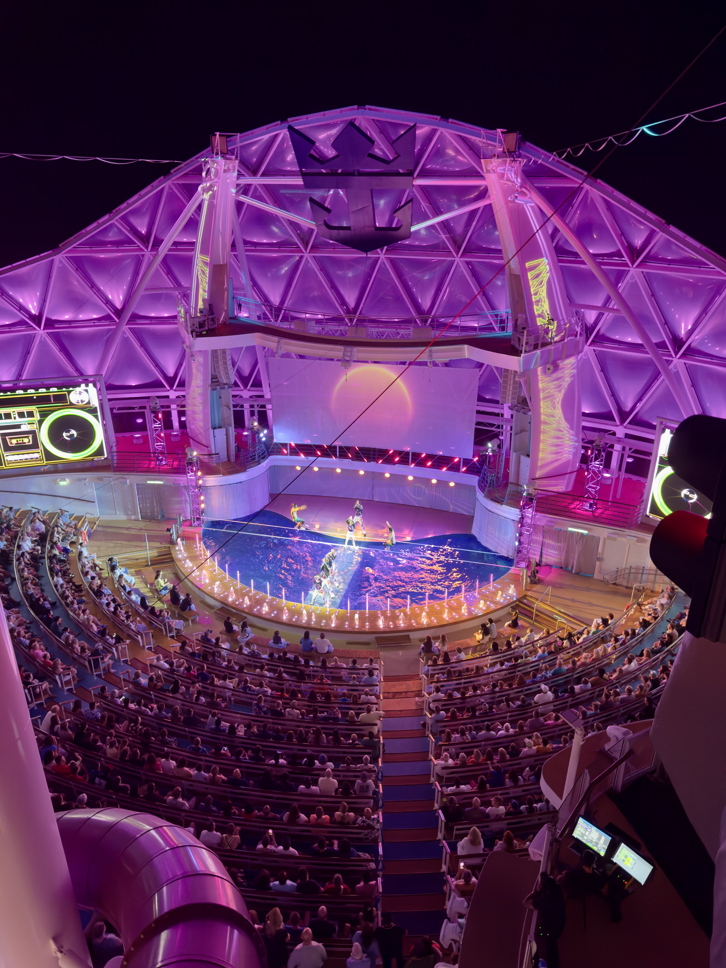 Cruise ship theater with purple lighting and acrobatic performance
