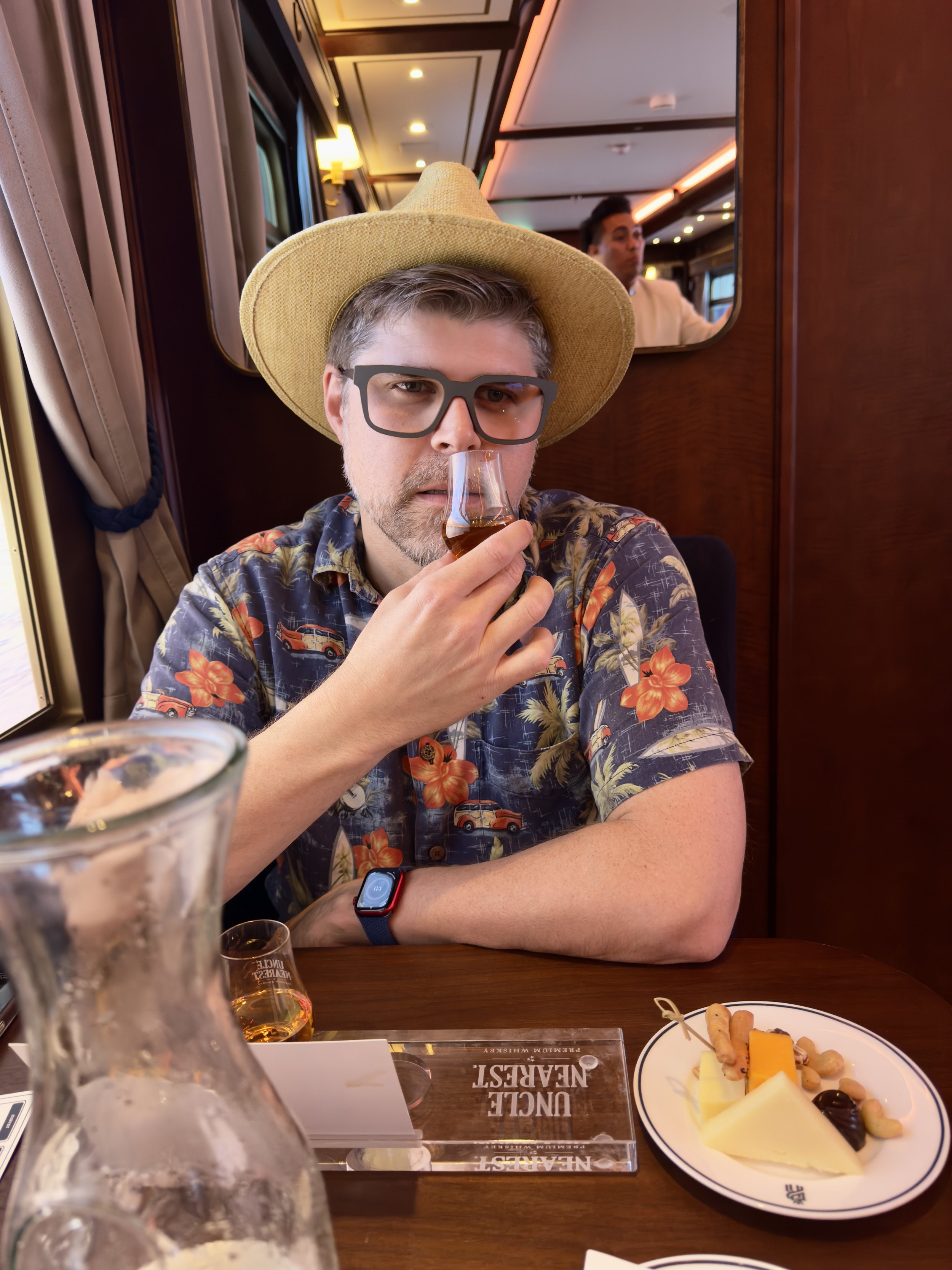 Man in cowboy hat tasting whiskey on luxury cruise ship