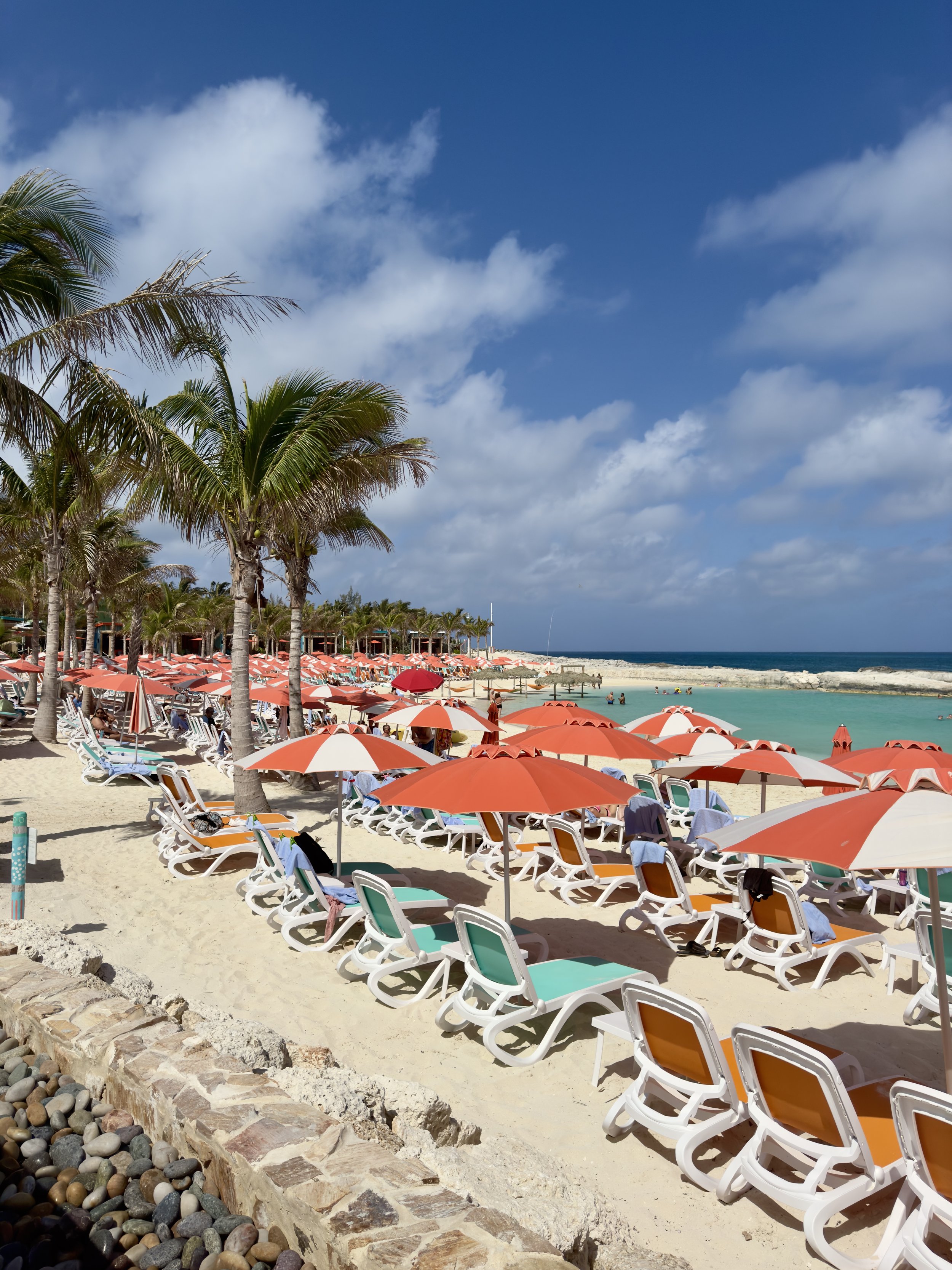 Tropical beach resort with orange umbrellas and lounge chairs