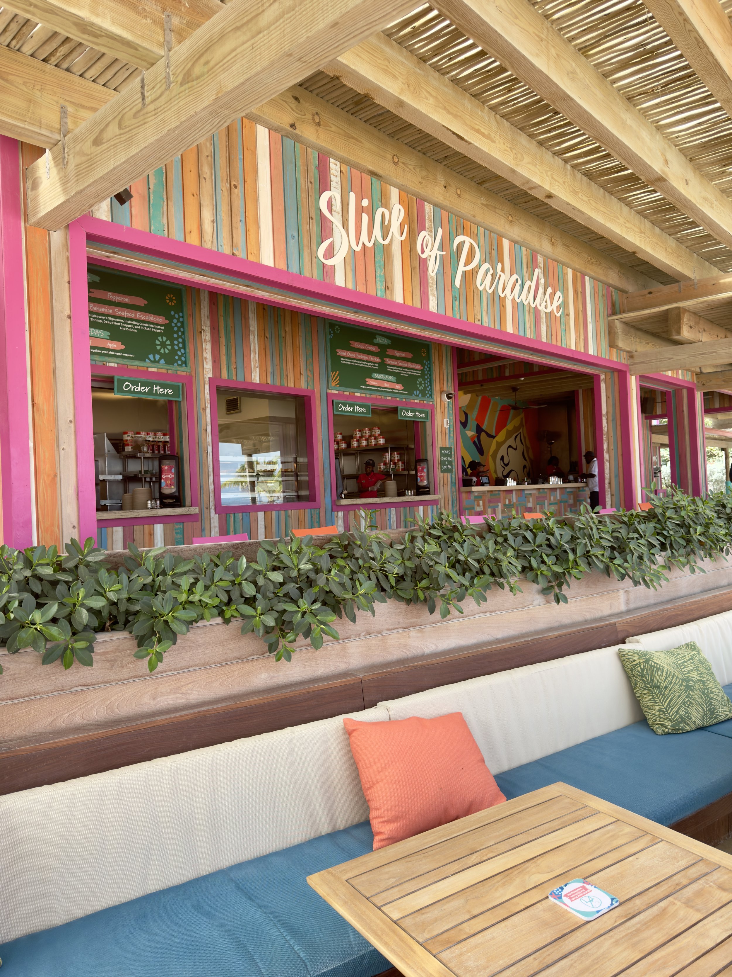 Slice of Paradise tropical restaurant storefront with colorful striped wood facade