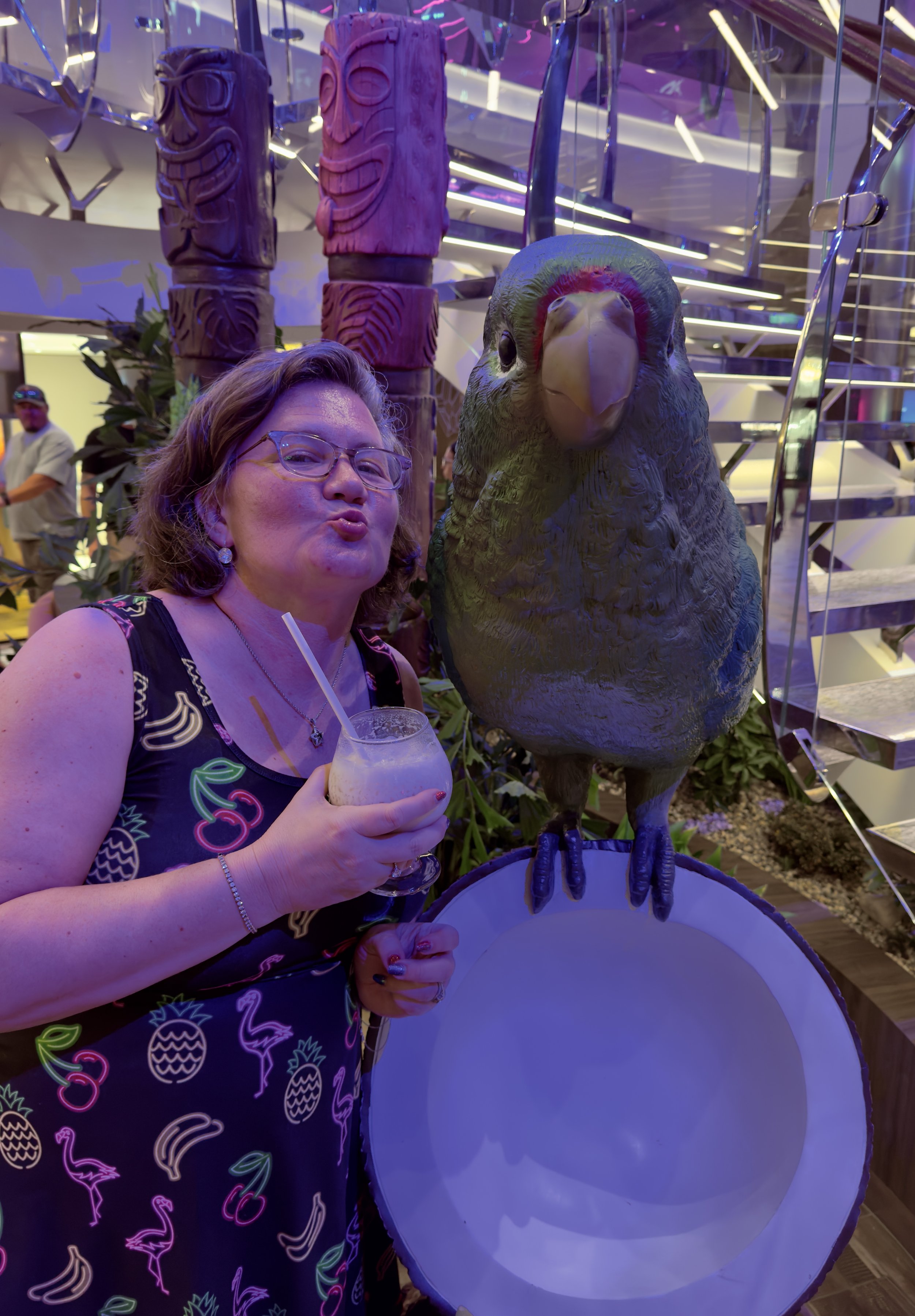 Woman feeds parrot at tropical cruise ship indoor venue