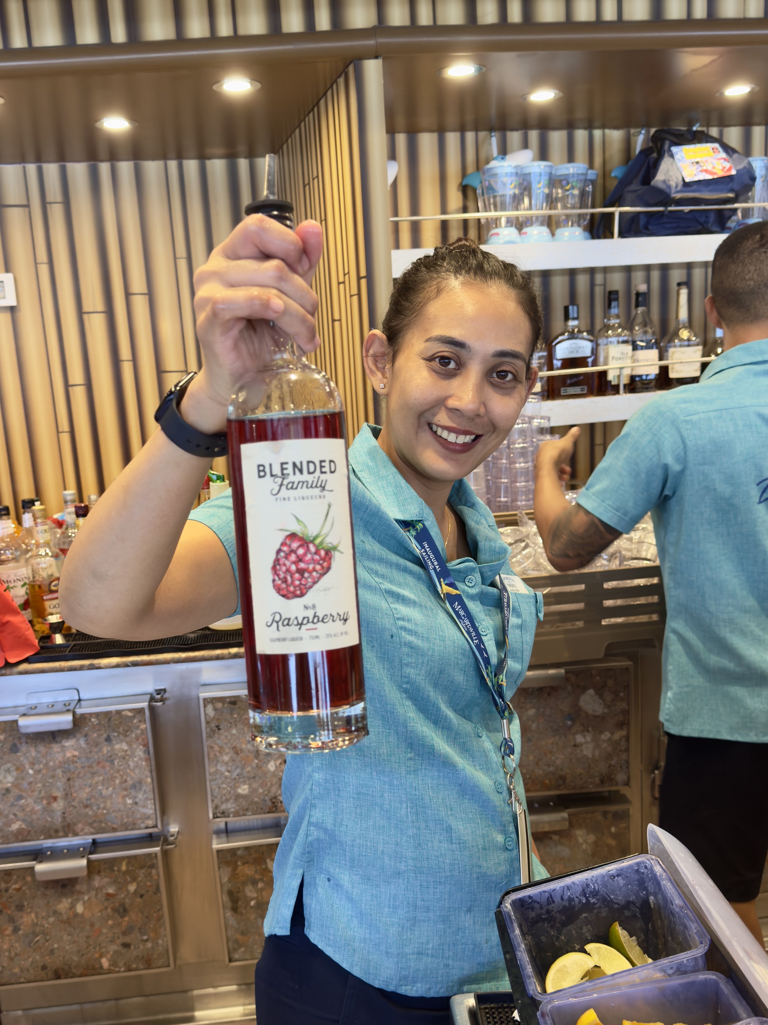 Staff member proudly displays Blended Family Raspberry liqueur at distillery tasting