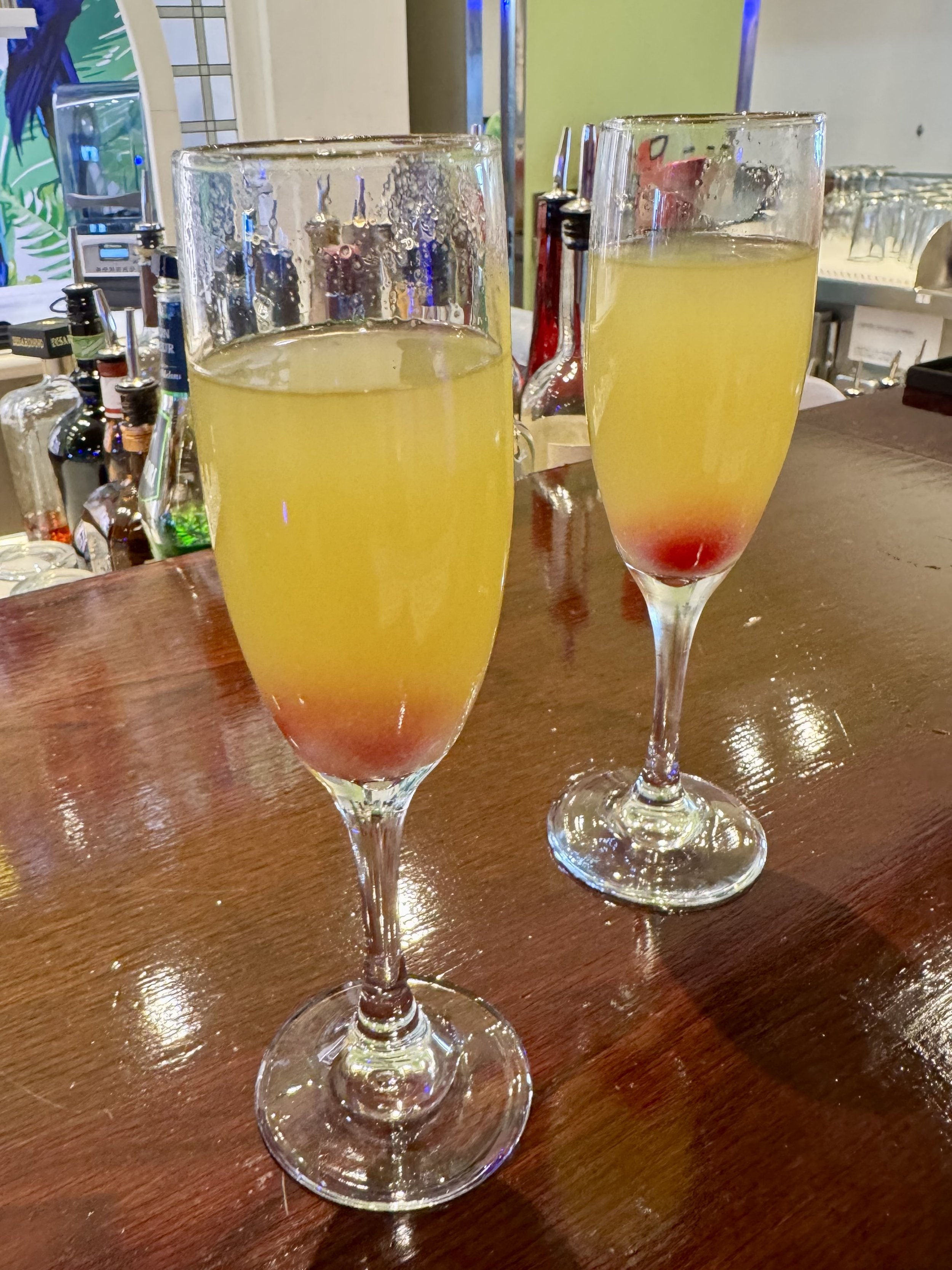 Two mimosa cocktails with grenadine at bar counter