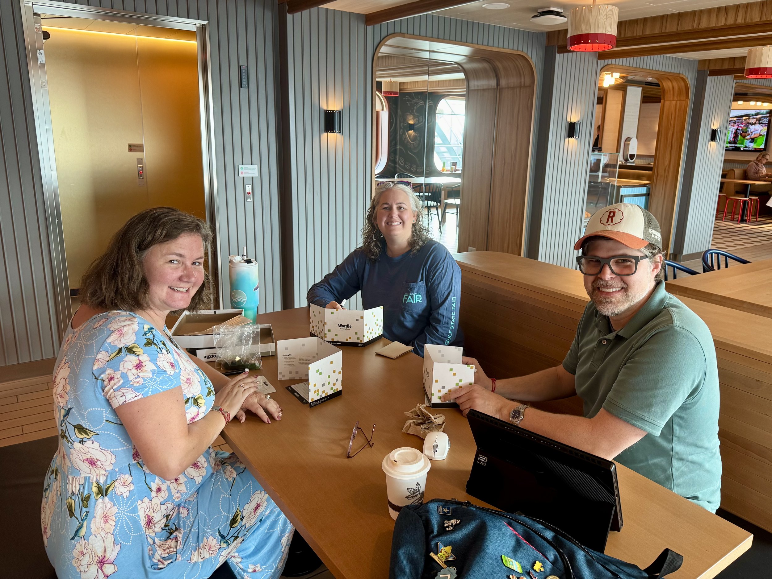 Three people enjoying beverages at modern cruise ship dining venue