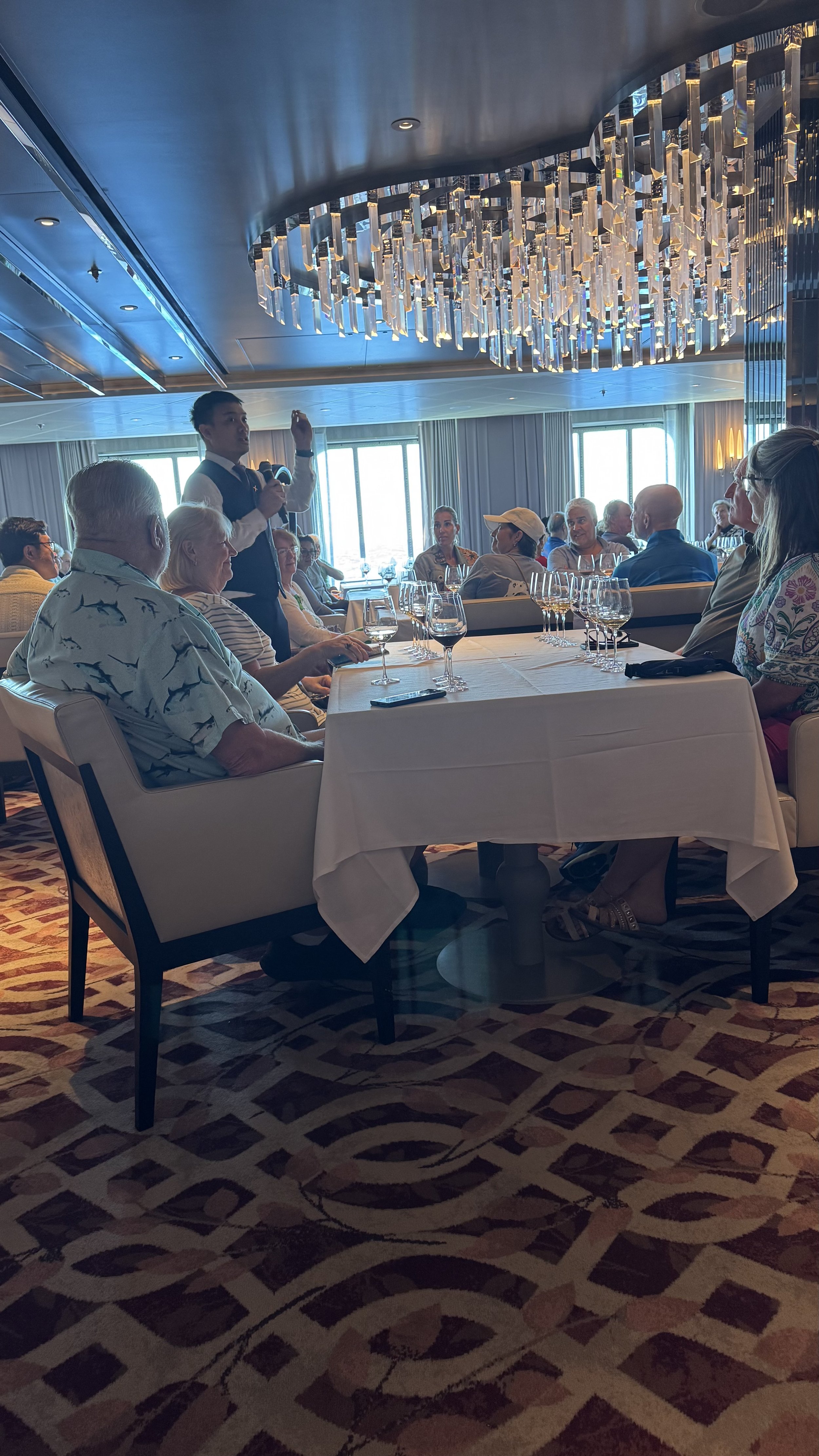 Cruise ship dining room presentation with elegant chandelier and guests