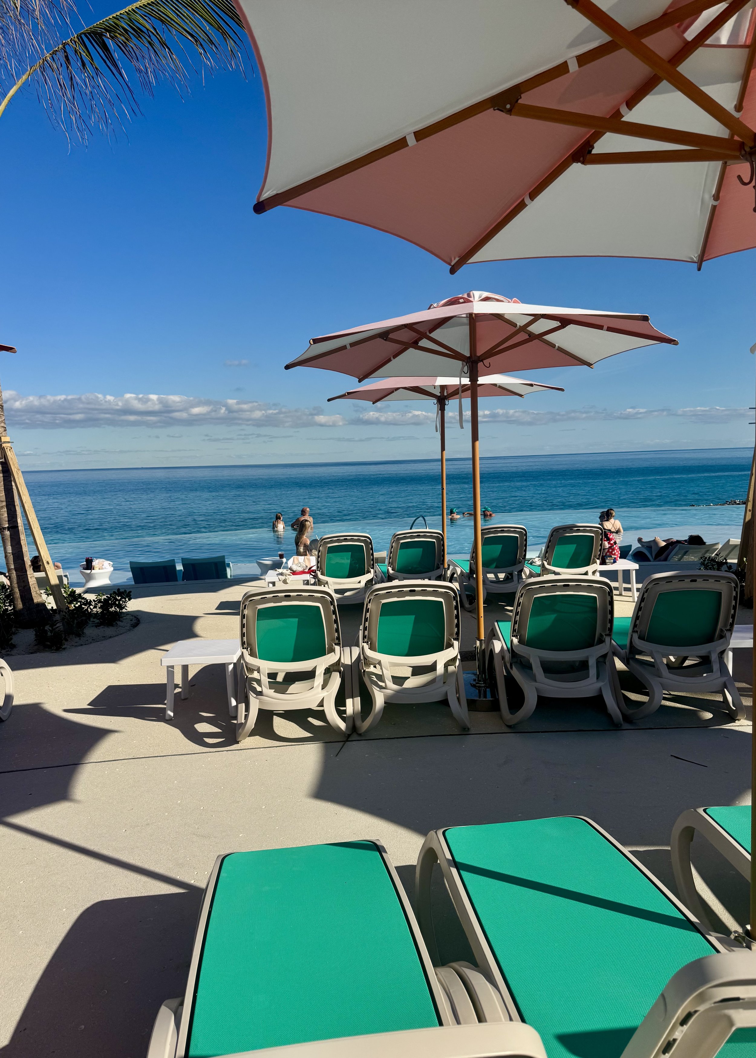 Beach lounge chairs and umbrellas overlooking turquoise ocean water