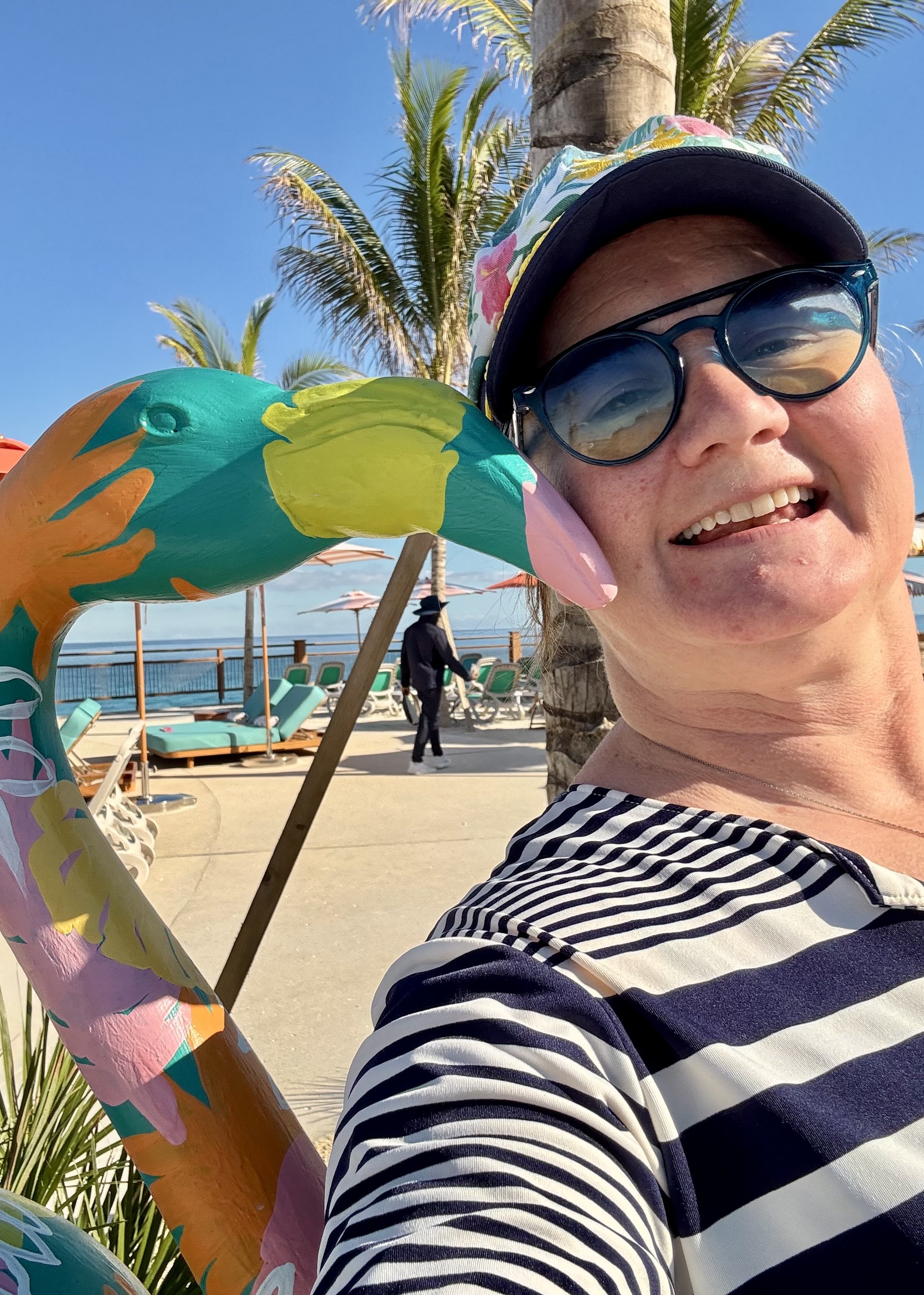 Person holding colorful fish sculpture at beach boardwalk