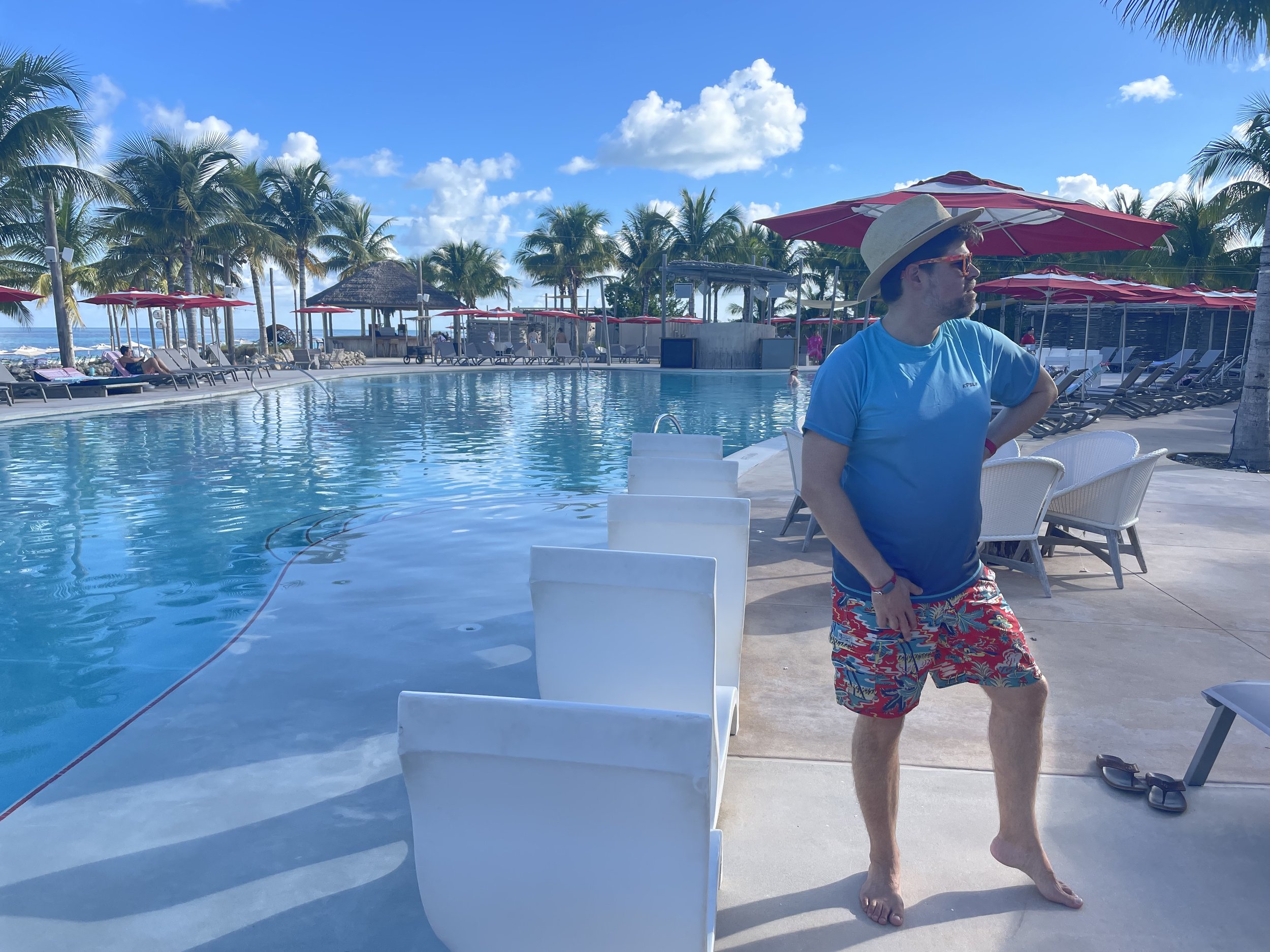 Man at cruise ship pool deck in tropical setting