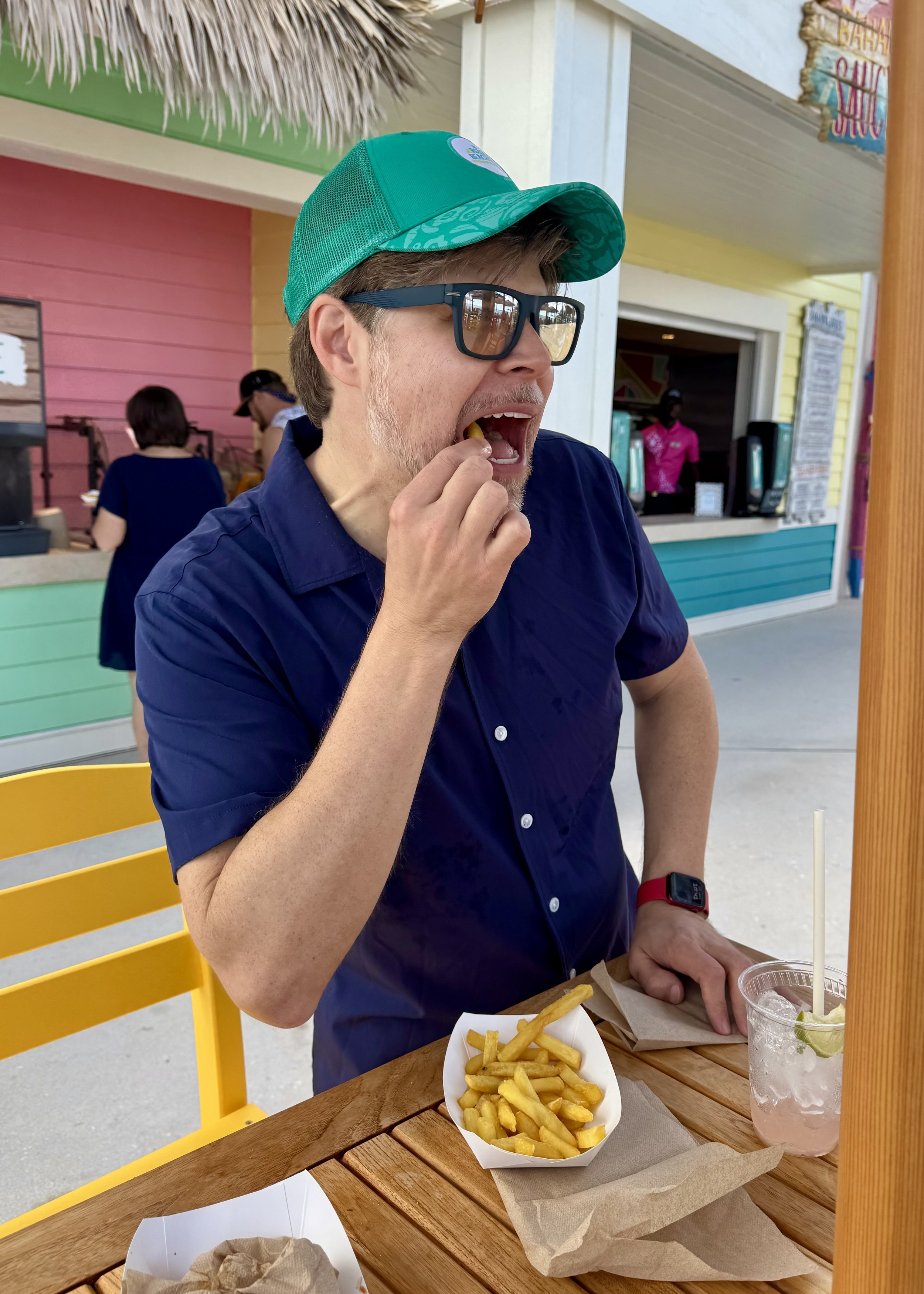 Man enjoying French fries at casual beachside restaurant