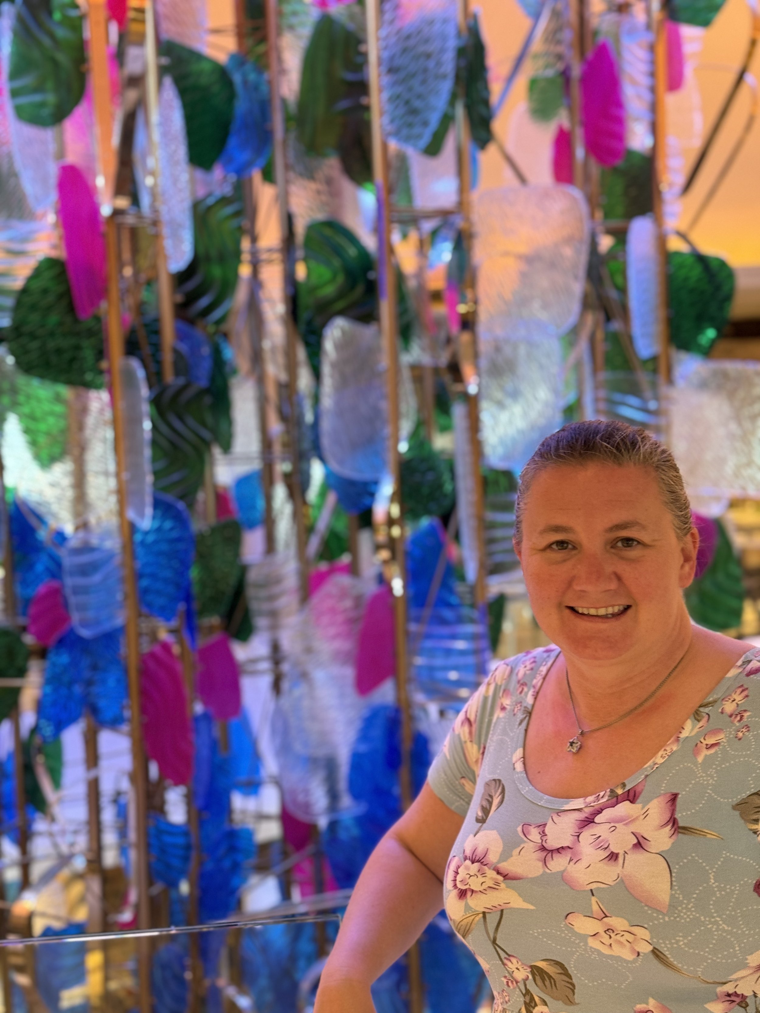 Woman smiling by colorful hanging laundry on clotheslines