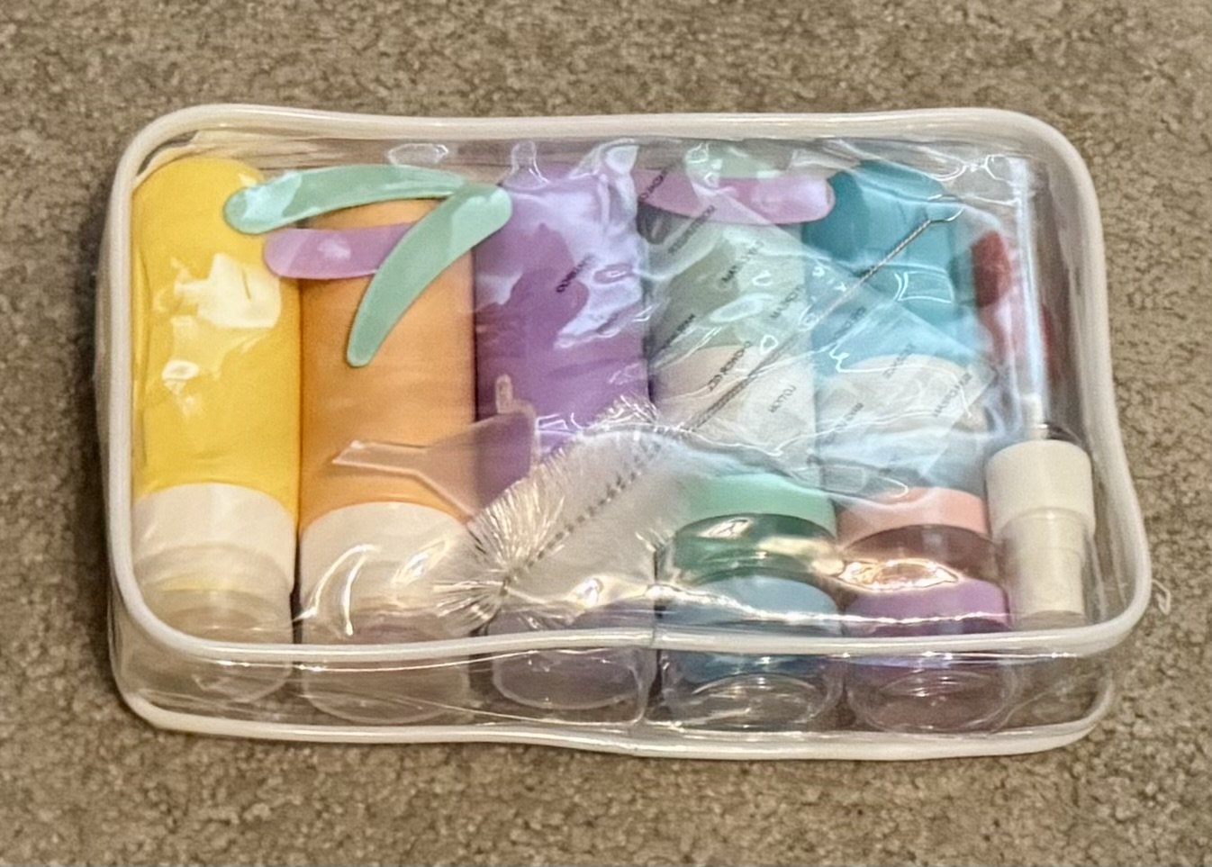 Travel-sized toiletries and beauty products organized in clear container