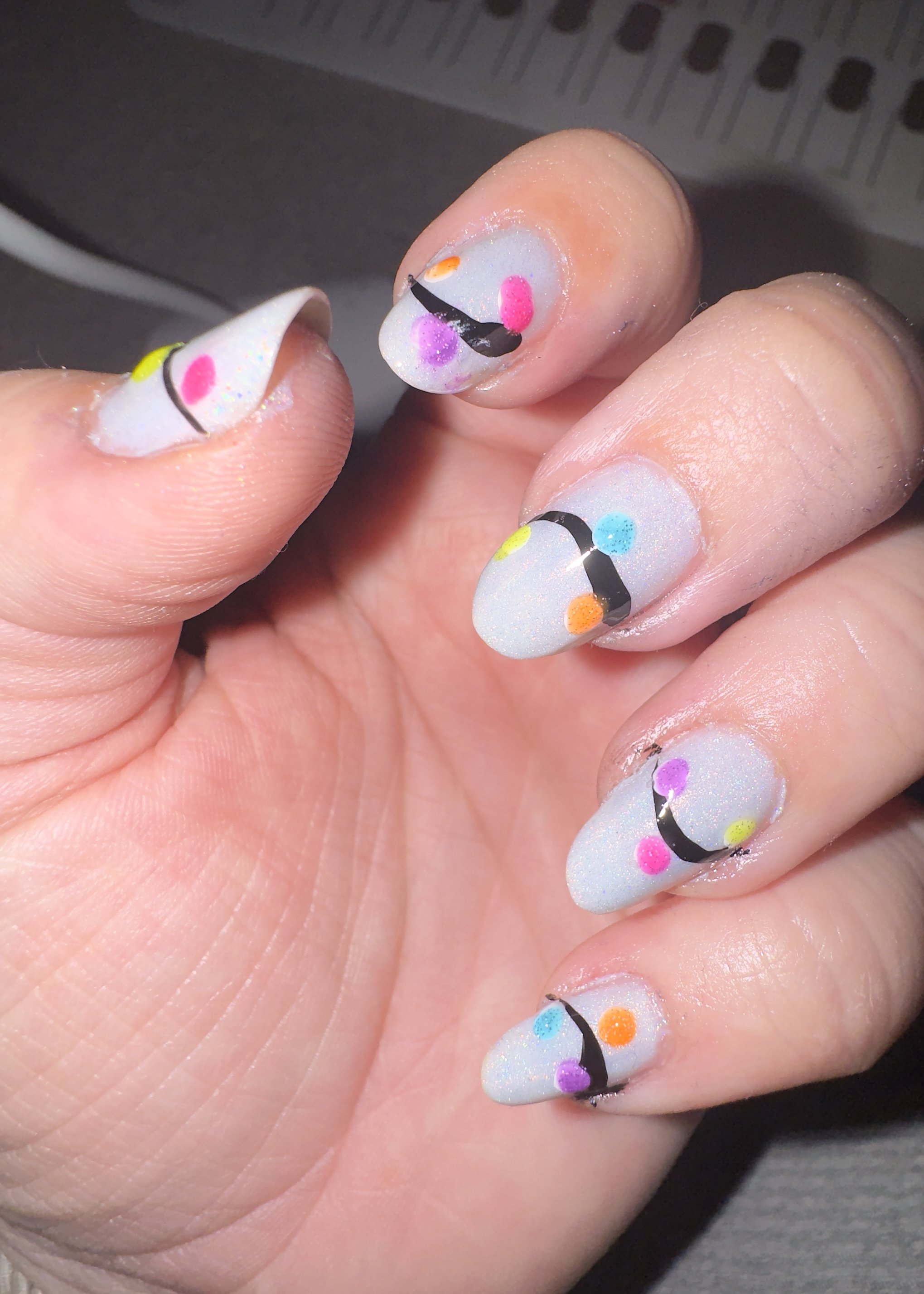 Playful nail art with colorful smiling faces and sunglasses design