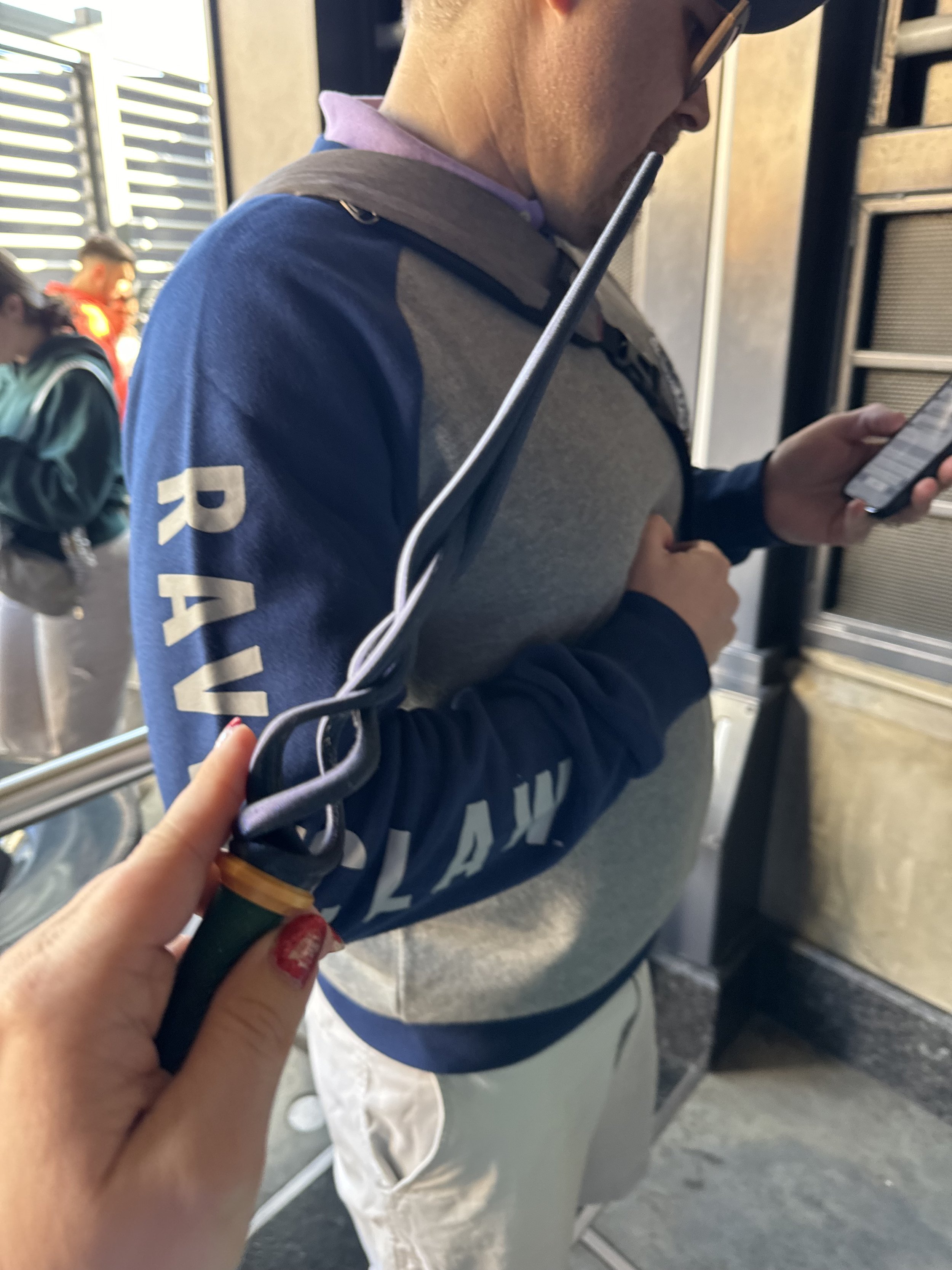 Man wearing RAW branded jacket holds phone on cruise ship